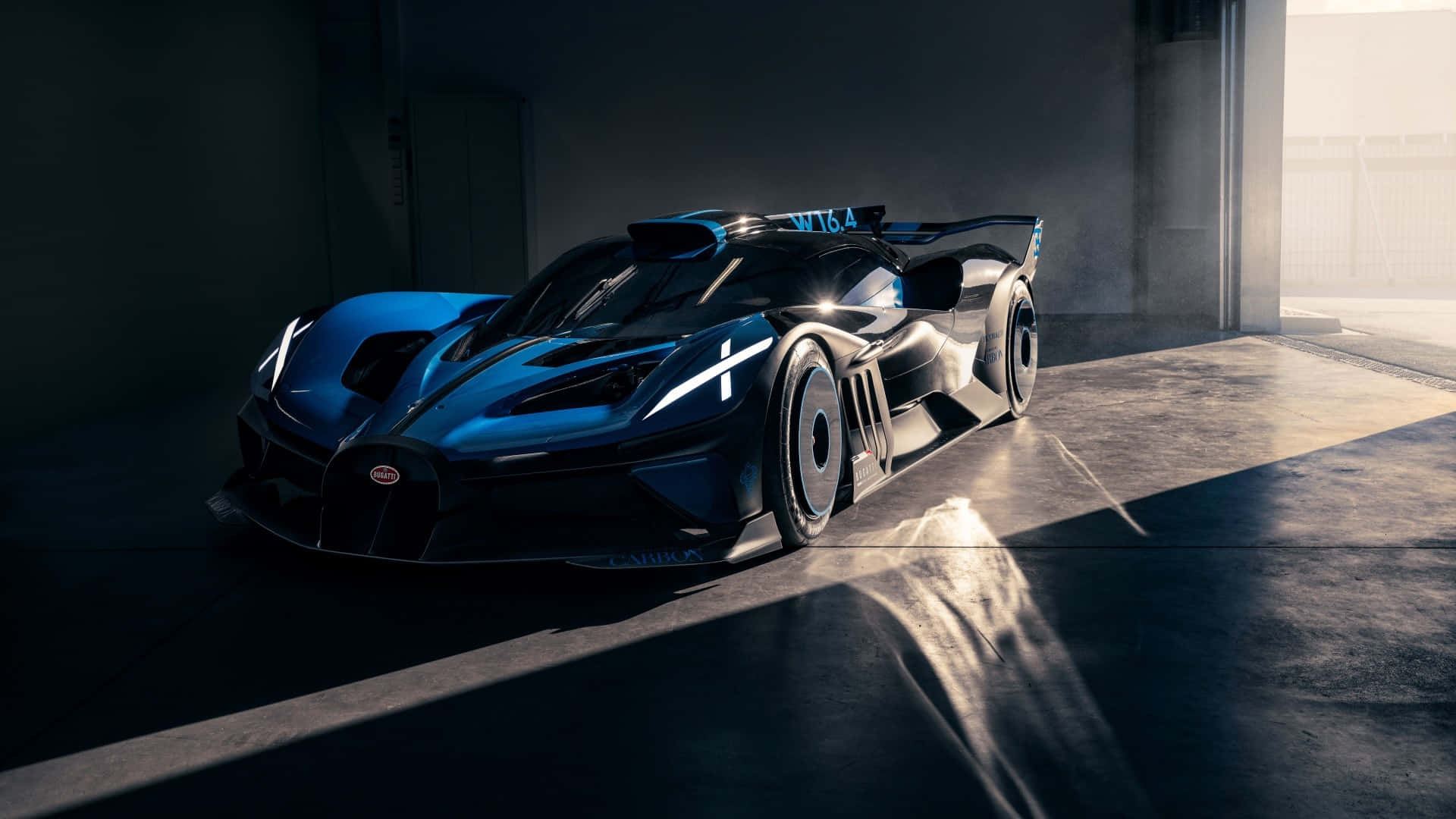 Bugatti Bolide 桌布 壁紙 — 一架流線型藍黑布加迪超跑在混凝土車庫中，於戲劇性的陽光照射下閃閃發光。