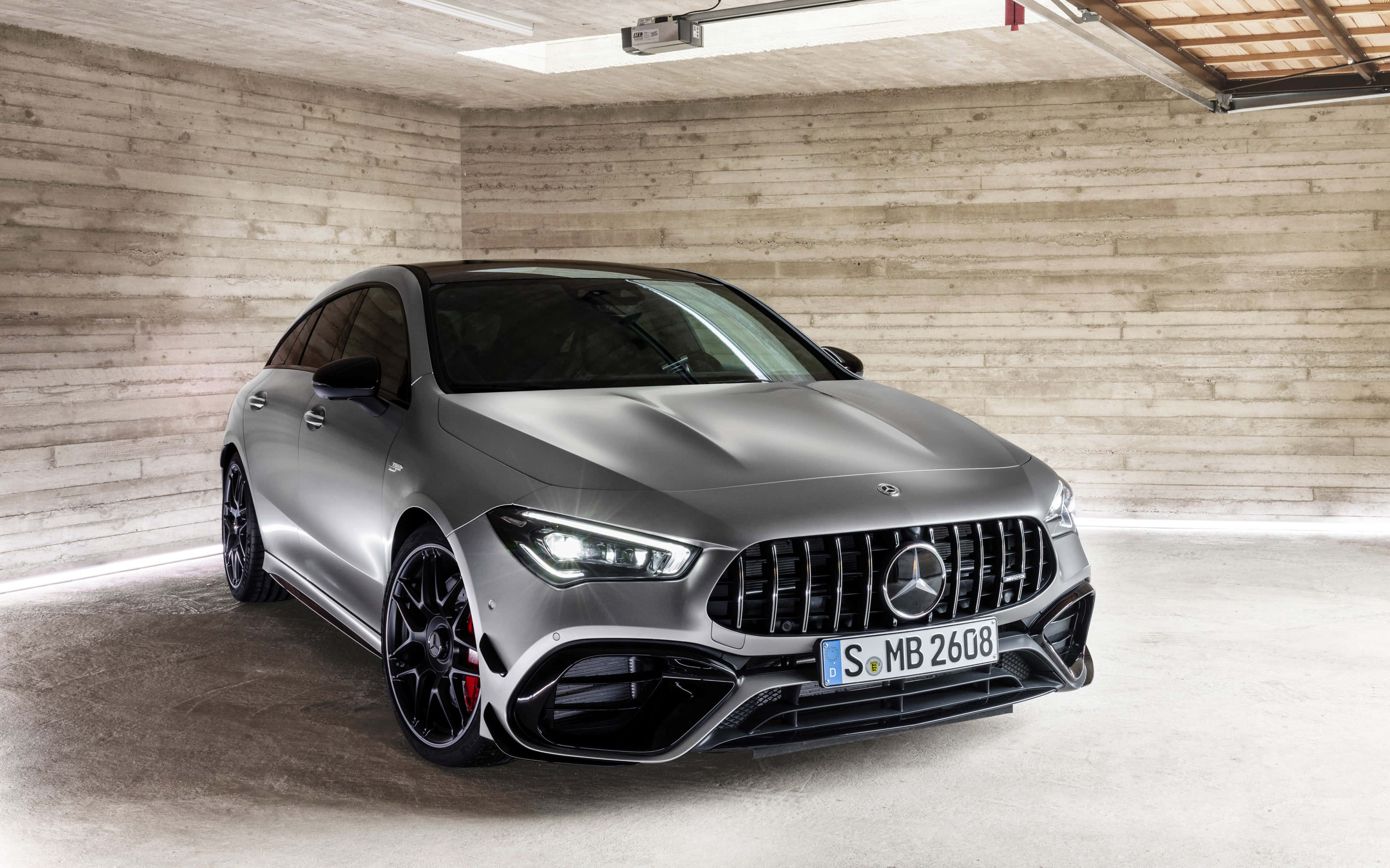 Mercedes Benz Cla-class 桌布 壁紙 — 一架時尚的啞光灰色 Mercedes-AMG CLA 45 S 停放在一個簡約的混凝土車庫中，帶有裸露的木樑。