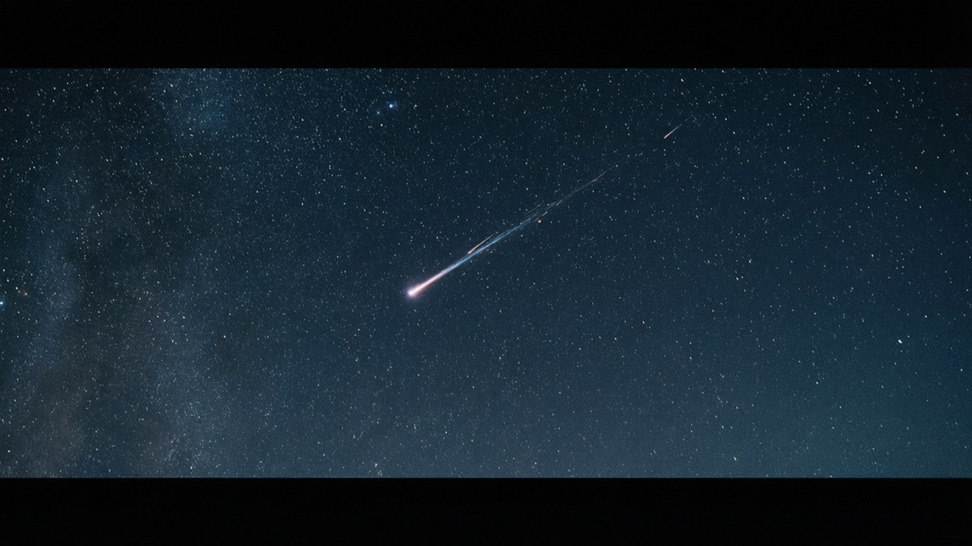 一顆發光的流星在佈滿星星的夜空中留下一道軌跡，銀河清晰可見。