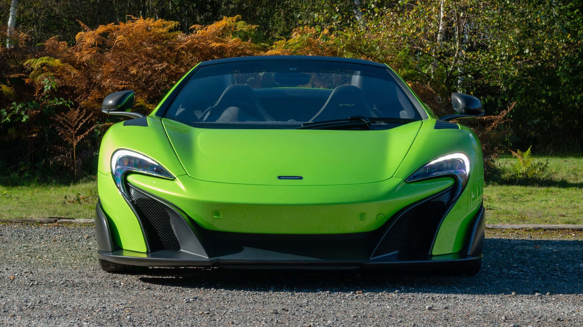 Mclaren 675lt Spider 桌布 壁紙 — 一輛充滿活力的萊姆綠色McLaren跑車停在碎石上，背景是秋天的樹葉。