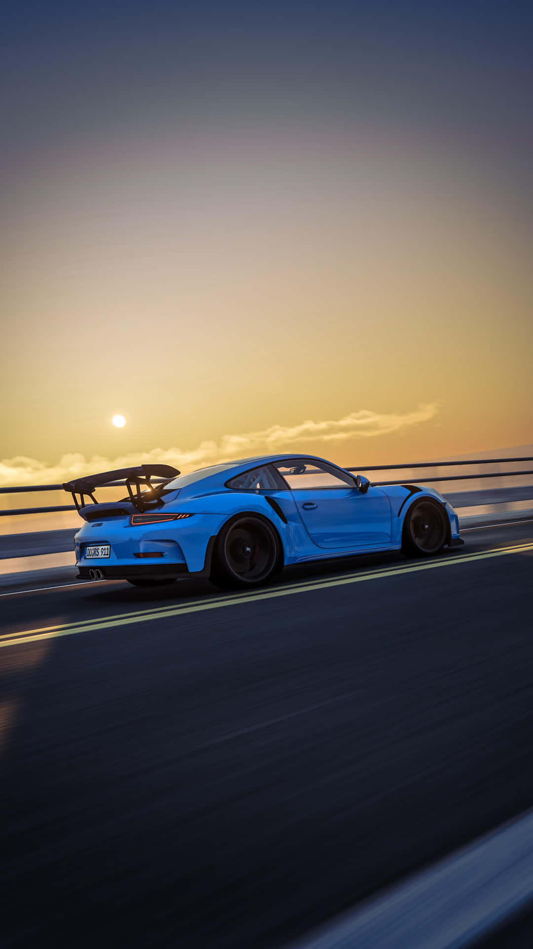  壁紙 — 一輛充滿活力的藍色保時捷911 GT3 RS在日落時分沿著海岸高速公路疾馳，帶有動態模糊和金色天空。
