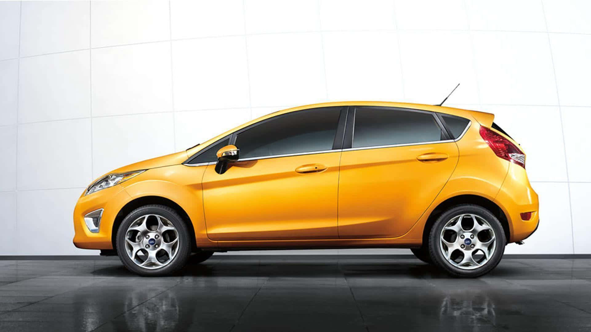Ford Fiesta 桌布 壁紙 — 一輛充滿活力的黃色福特 Fiesta 掀背車在攝影棚燈光下，於潔白瓷磚牆和深色反光地板上閃閃發光。