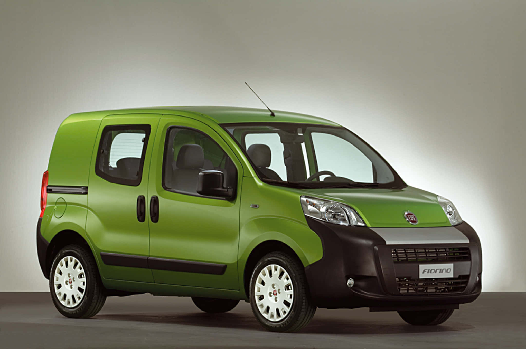 Fiat Fiorino 桌布 壁紙 — 一輛充滿活力的青檸綠色菲亞特 Fiorino 緊湊型貨車，帶有黑色飾件和白色合金輪圈，在中性攝影棚背景下展示。