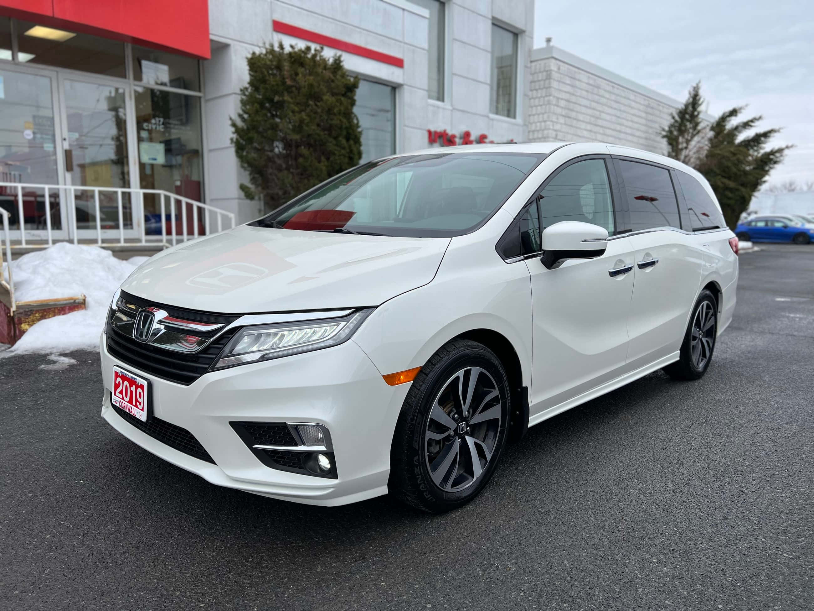 Honda Odyssey 桌布 壁紙 — 一輛純白色的2019年本田Odyssey廂型車停放在經銷商外，附近有雪堆。
