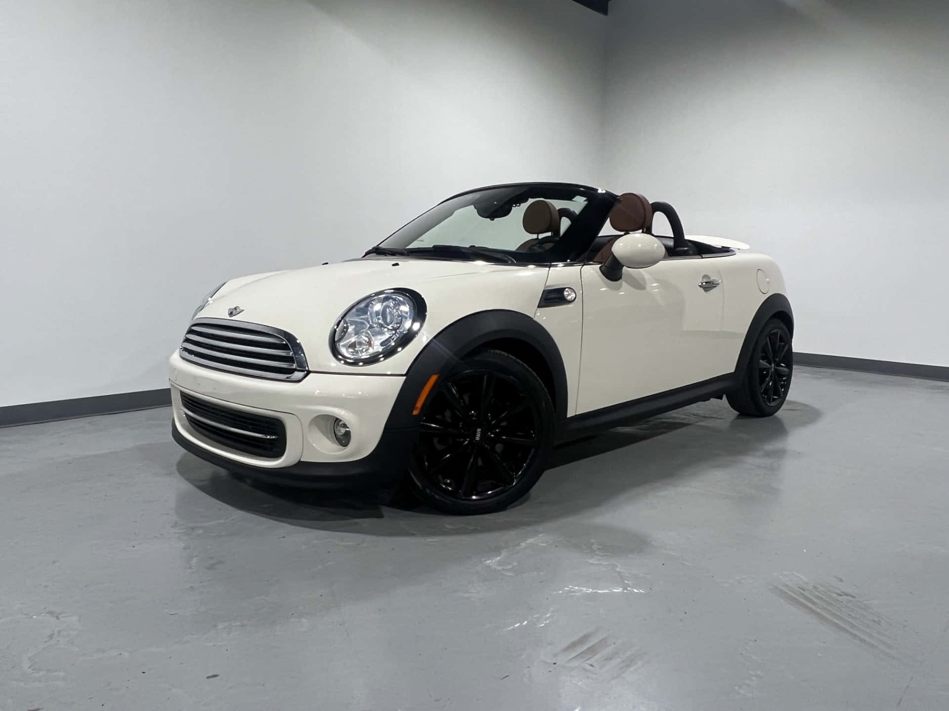  壁紙 — 一輛純白色的MINI Cooper敞篷車，帶有黑色飾件和車輪，停放在簡約的攝影棚空間中。