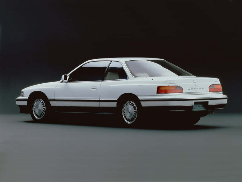 Honda Legend 桌布 壁紙 — 一輛純白色的Lexus LS400轎跑車在攝影棚燈光下，於深色漸變背景前滑行。
