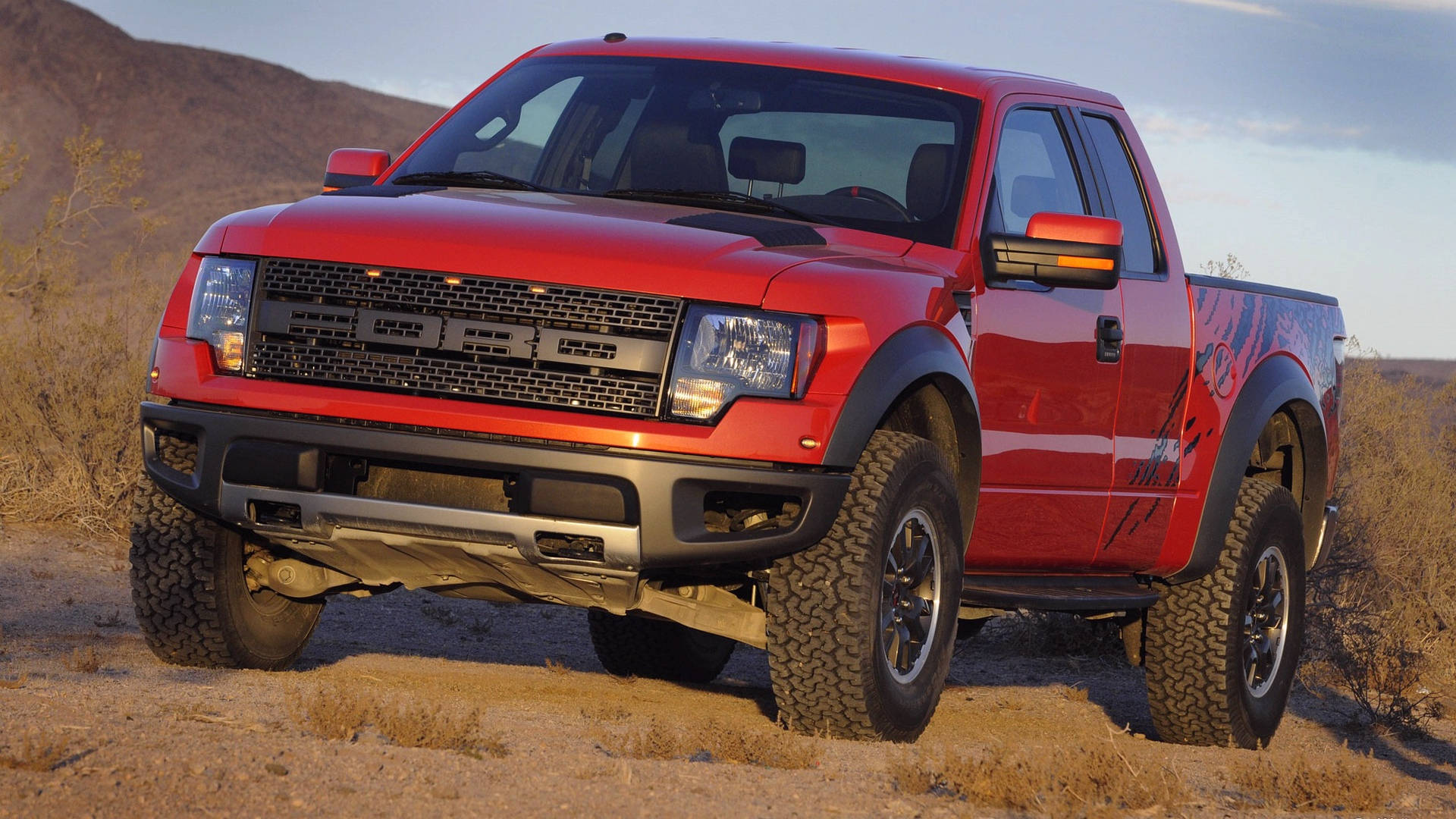 紅色福特F-150 Raptor卡車在日落時停放在沙漠地形上。 — 福特猛禽 壁紙
