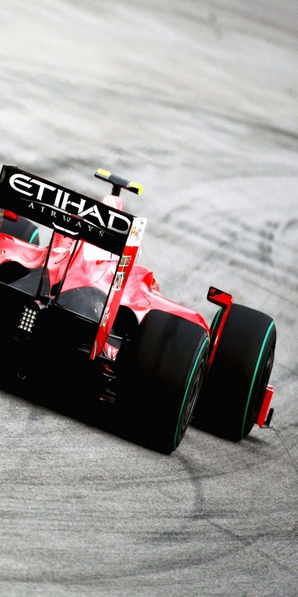 在灰色賽道上飛馳的紅黑色F1賽車。 — F1 壁紙
