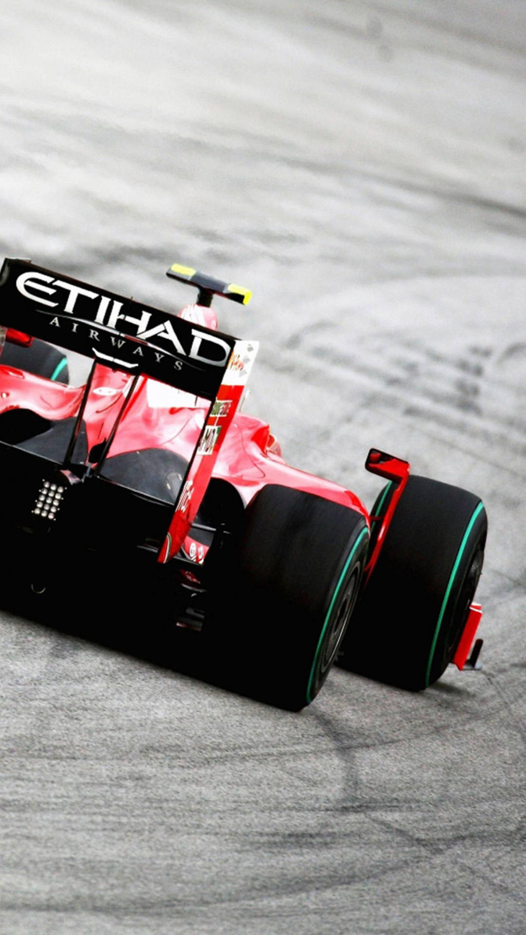 紅黑色一級方程式賽車在灰色賽道上疾馳。 — F1 壁紙
