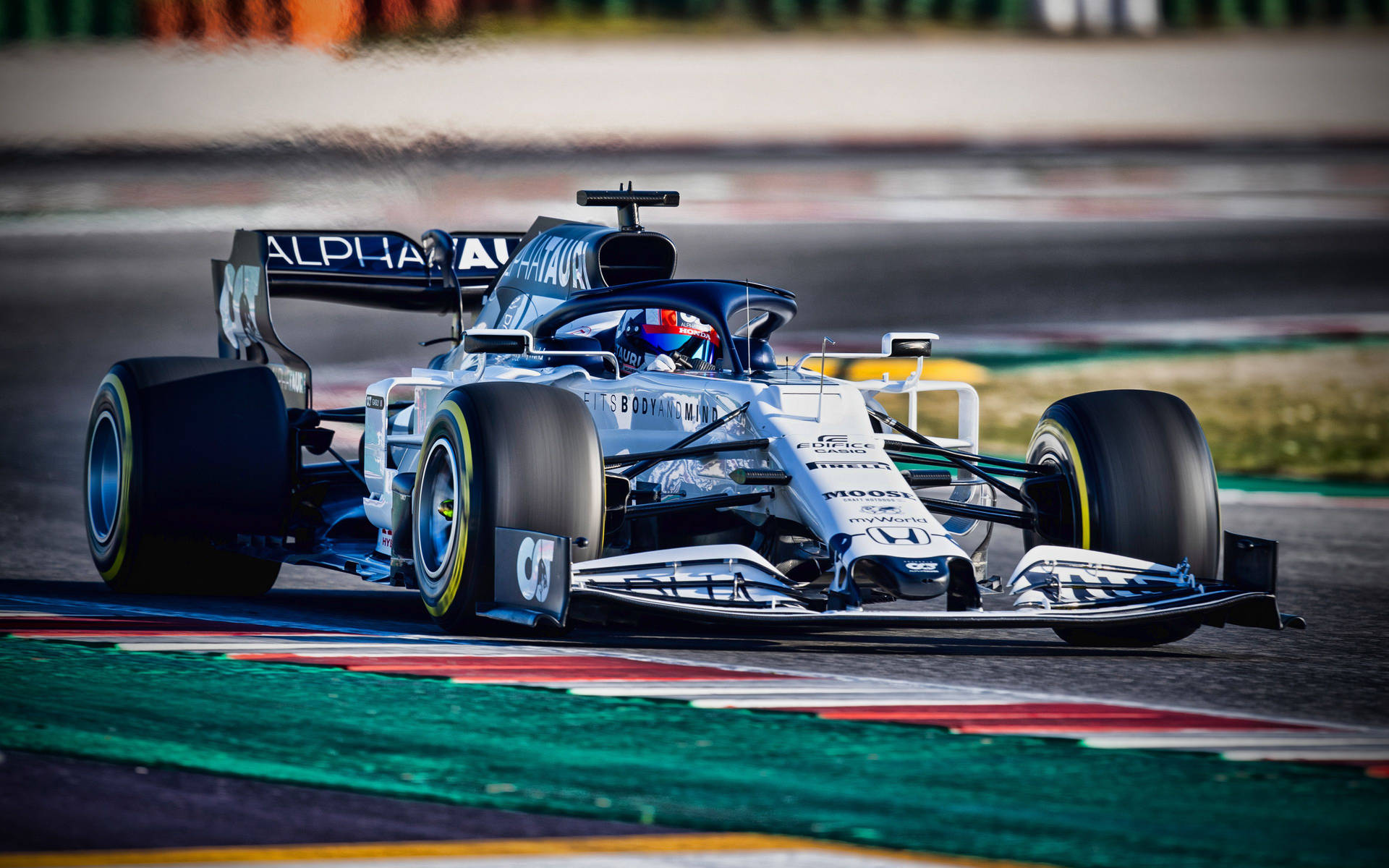 一輛一級方程式賽車在色彩繽紛的路緣賽道上飛馳。 — F1 壁紙