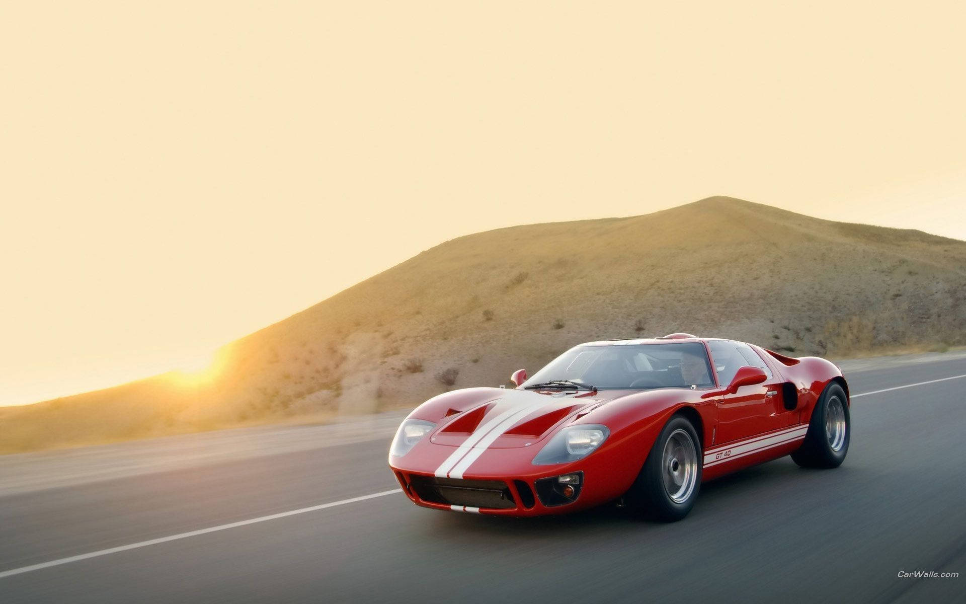 紅色福特GT40在金色日落下的沙漠公路上奔馳。 — 好看汽車 壁紙