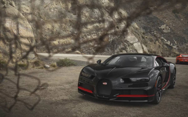 黑色Bugatti Chiron帶紅色飾邊停泊在山路上。 — 4K 壁紙