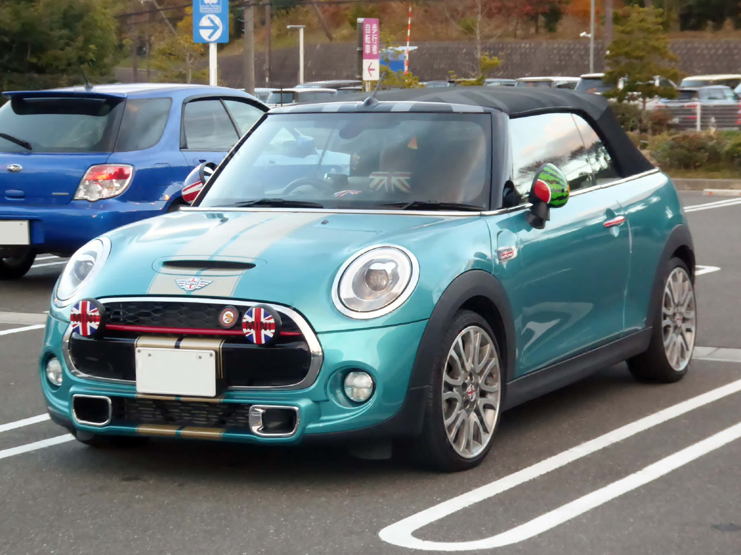 Mini Cooper Convertible 桌布 壁紙 — 一輛帶有Union Jack旗幟的藍綠色MINI Cooper敞篷車停放在日間停車場。