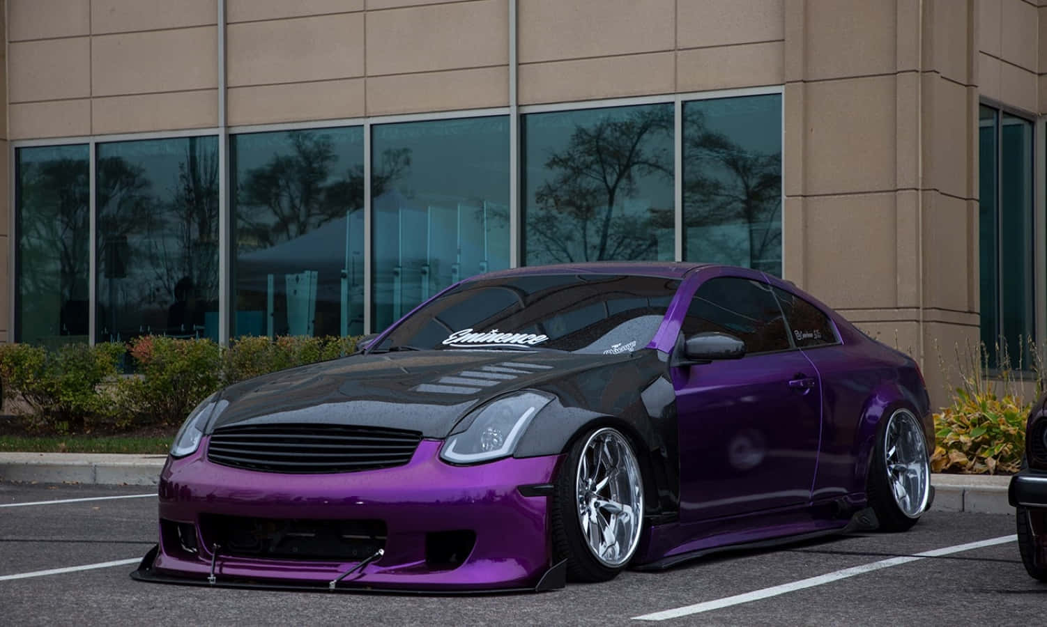Infiniti G35 桌布 壁紙 — 一輛低矮的紫色和黑色訂製跑車停放在現代玻璃建築前。