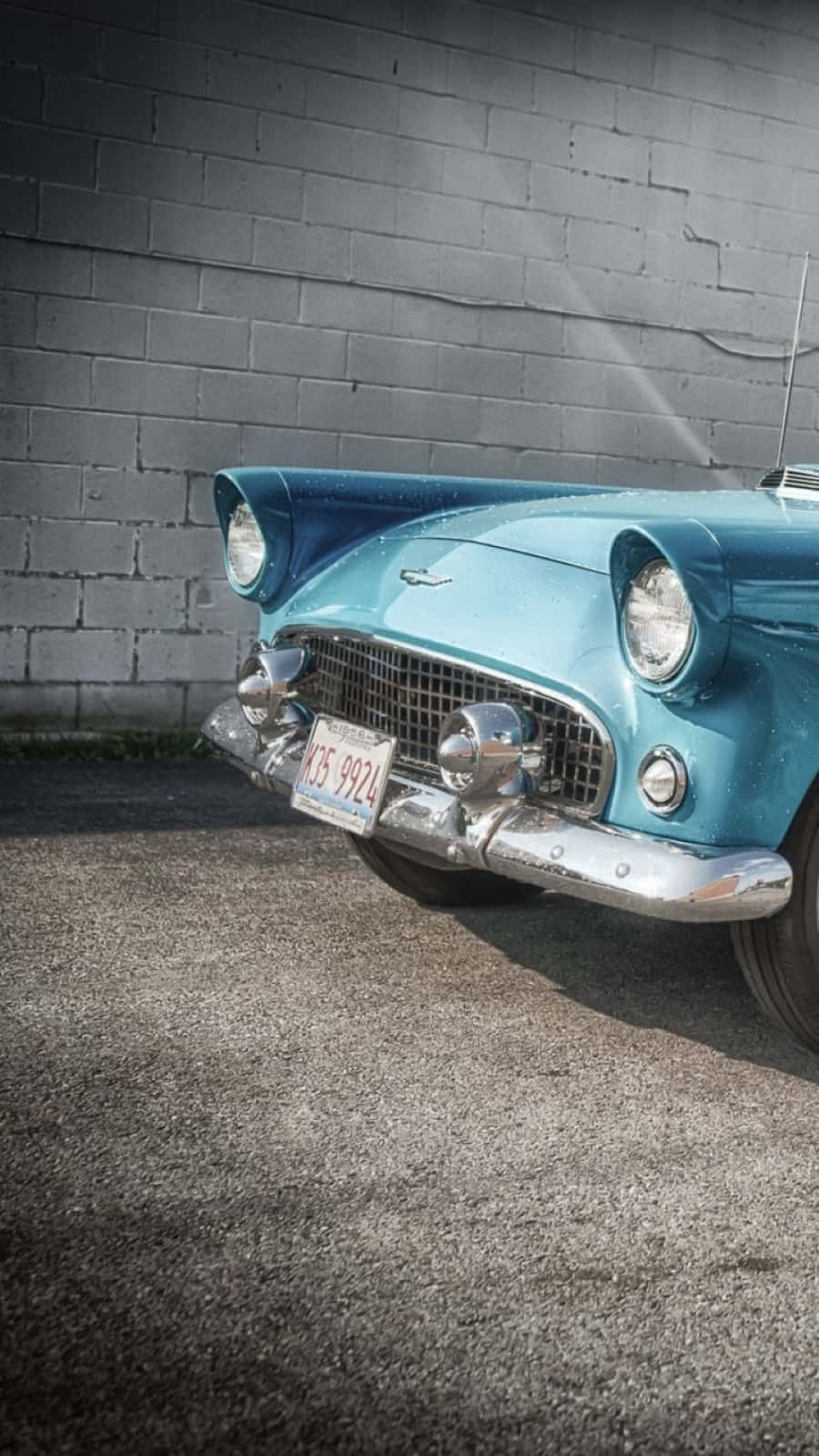 Ford Thunderbird 桌布 壁紙 — 一輛復古青綠色汽車帶有鍍鉻裝飾，停在灰色磚牆旁的瀝青路面上。
