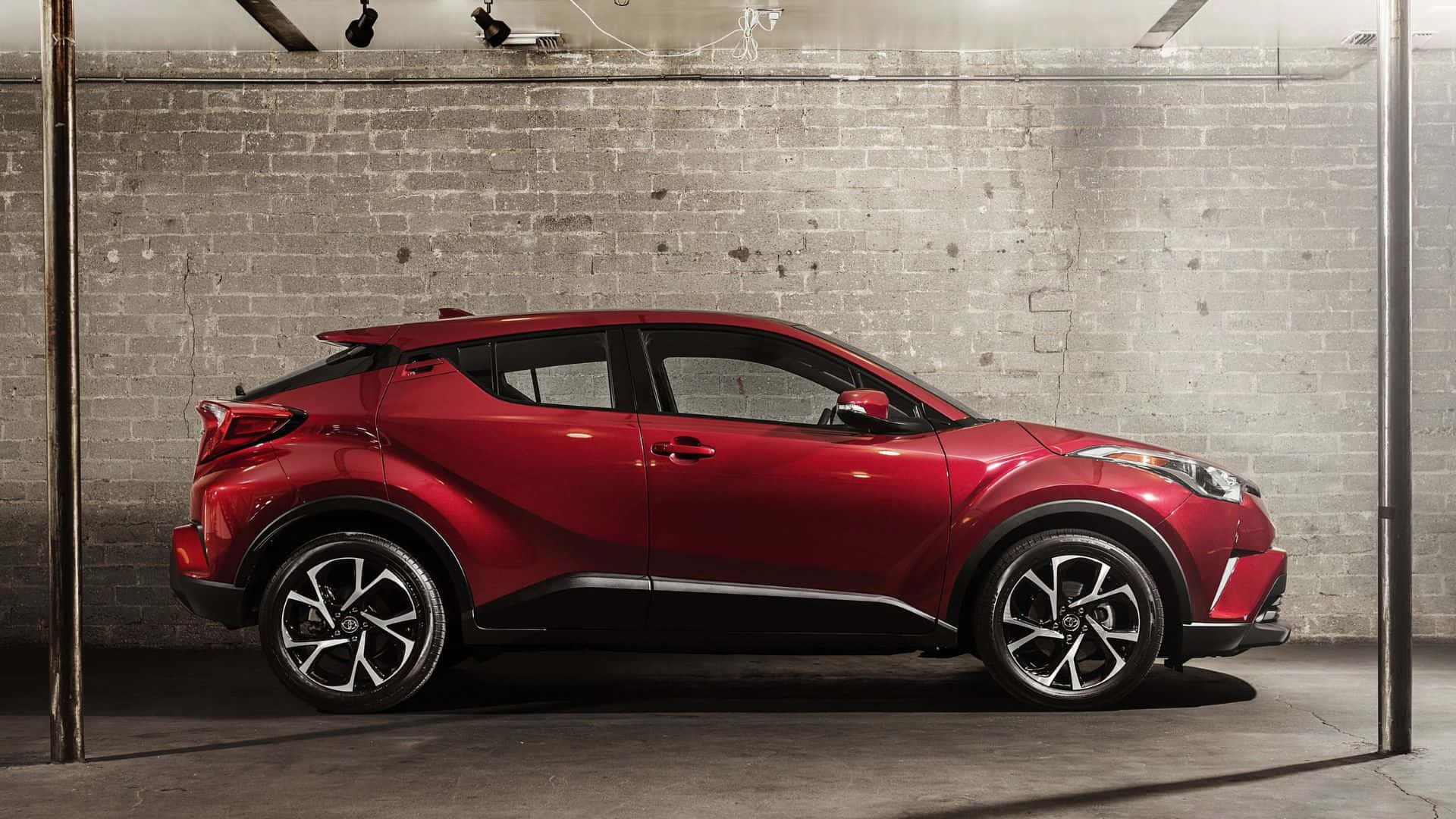 紅色緊湊型SUV停放在車庫的磚牆旁。 — Toyota Supra 壁紙