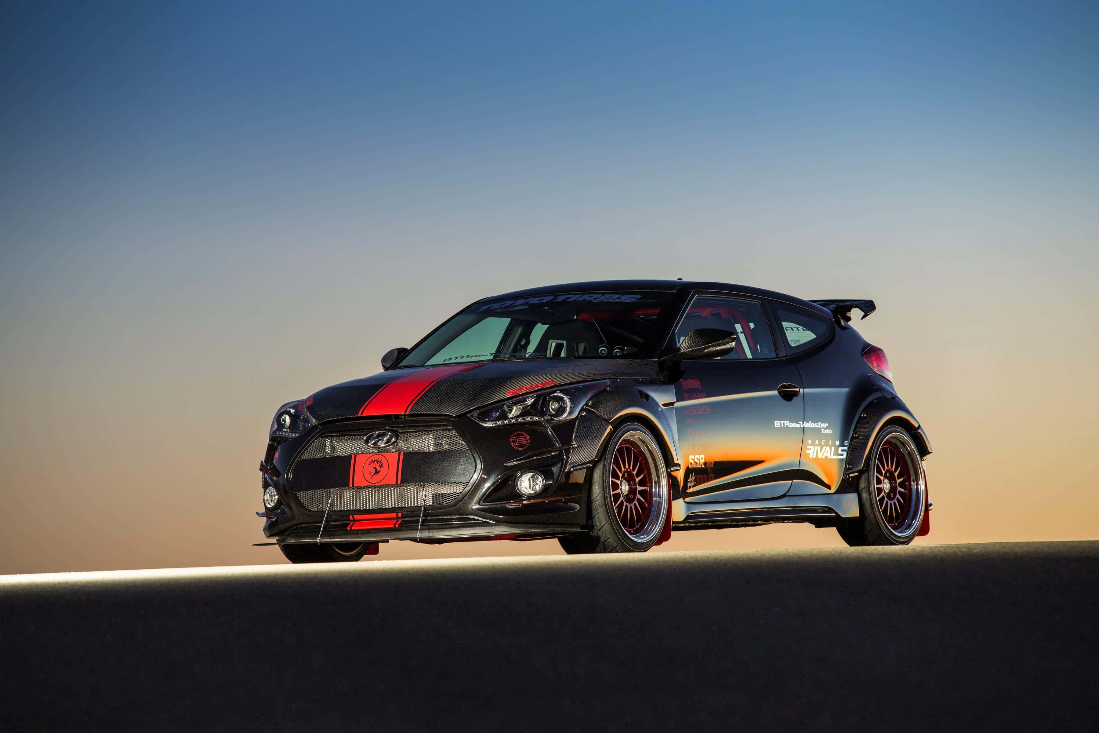 Hyundai Veloster 桌布 壁紙 — 一輛黑色現代Veloster N甩尾車，帶有紅色點綴和贊助商貼紙，在日落時分停在沙漠公路上。