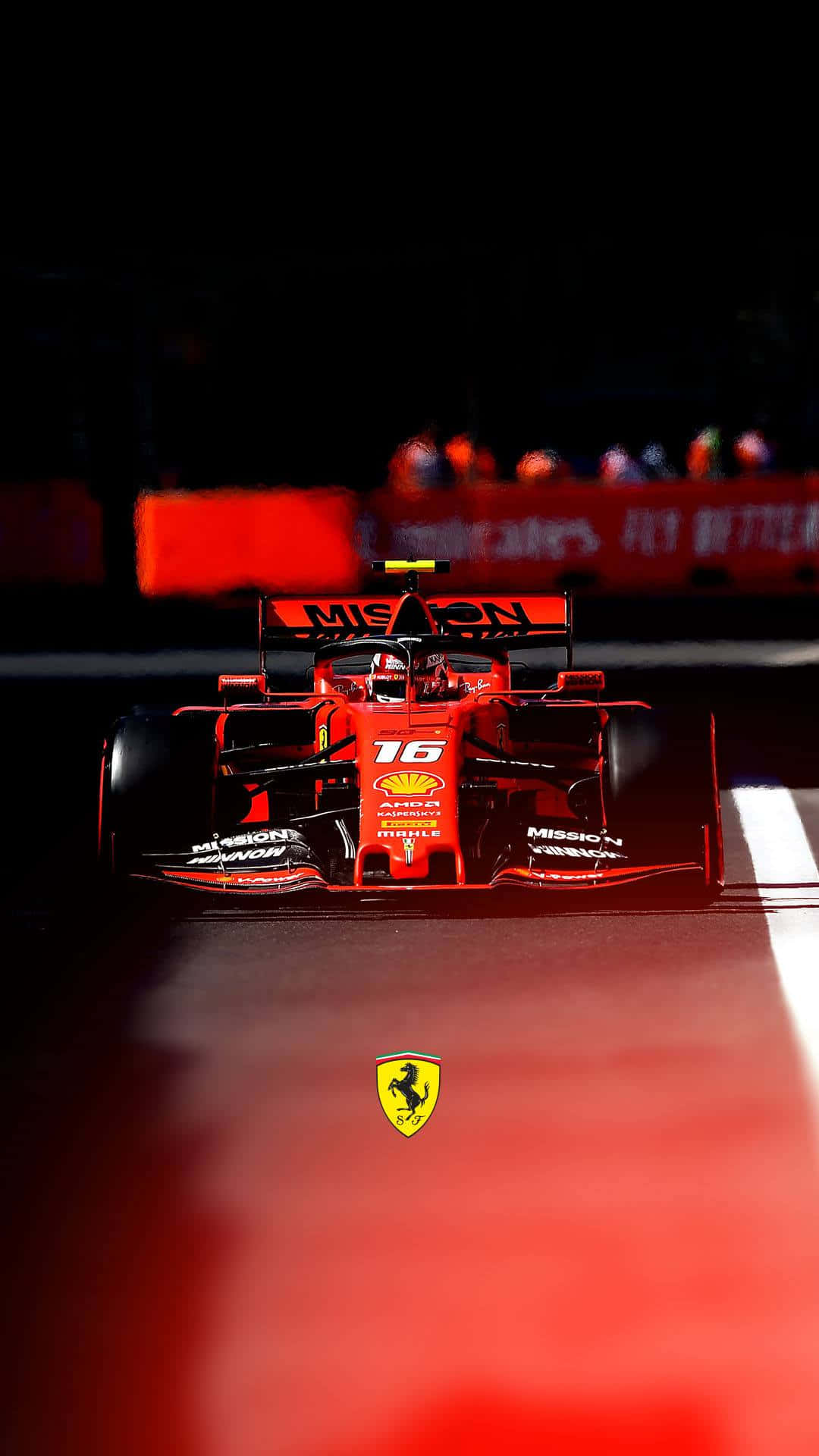  壁紙 — 一輛紅色法拉利一級方程式賽車，車號16，在夜間賽道燈光下行駛，背景是模糊的人群。