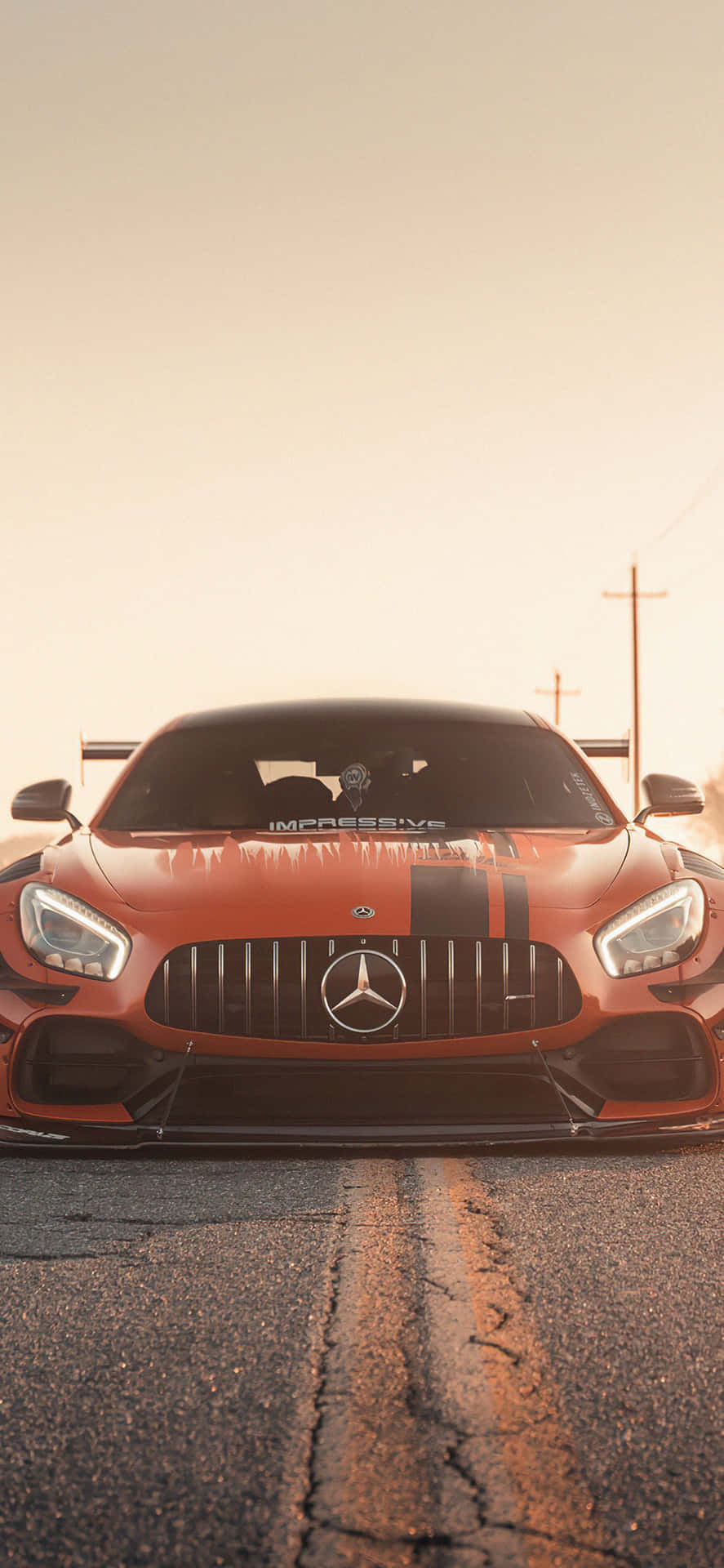 金色日落時龜裂路上的橙色Mercedes-AMG GT賽車。 — Amg Gt R 壁紙