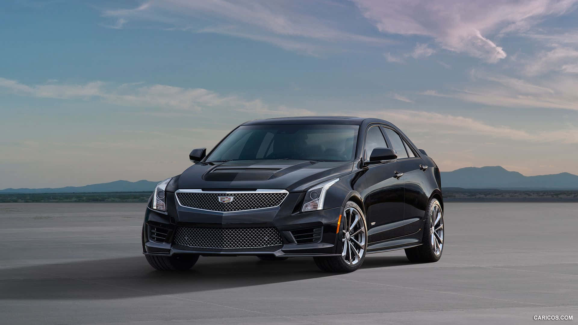Cadillac Ats 桌布 壁紙 — 一輛流線型的黑色Cadillac ATS-V轎車，在柔和的暮色天空下，矗立在廣闊的沙漠平原上，遠山依稀可見。