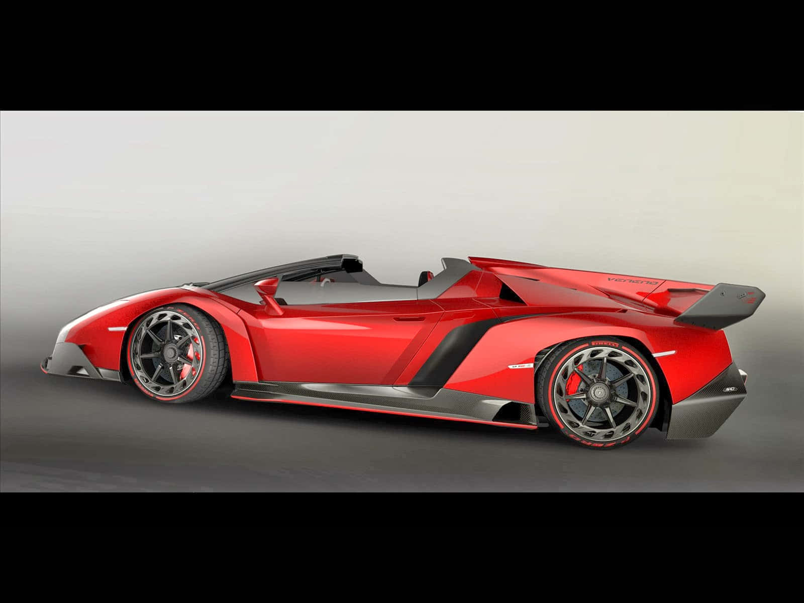 Lamborghini Veneno 桌布 壁紙 — 一輛流線型紅色藍寶堅尼 Veneno Roadster 敞篷跑車，帶有黑色飾邊和大車輪，在側面展示於中性工作室背景前。