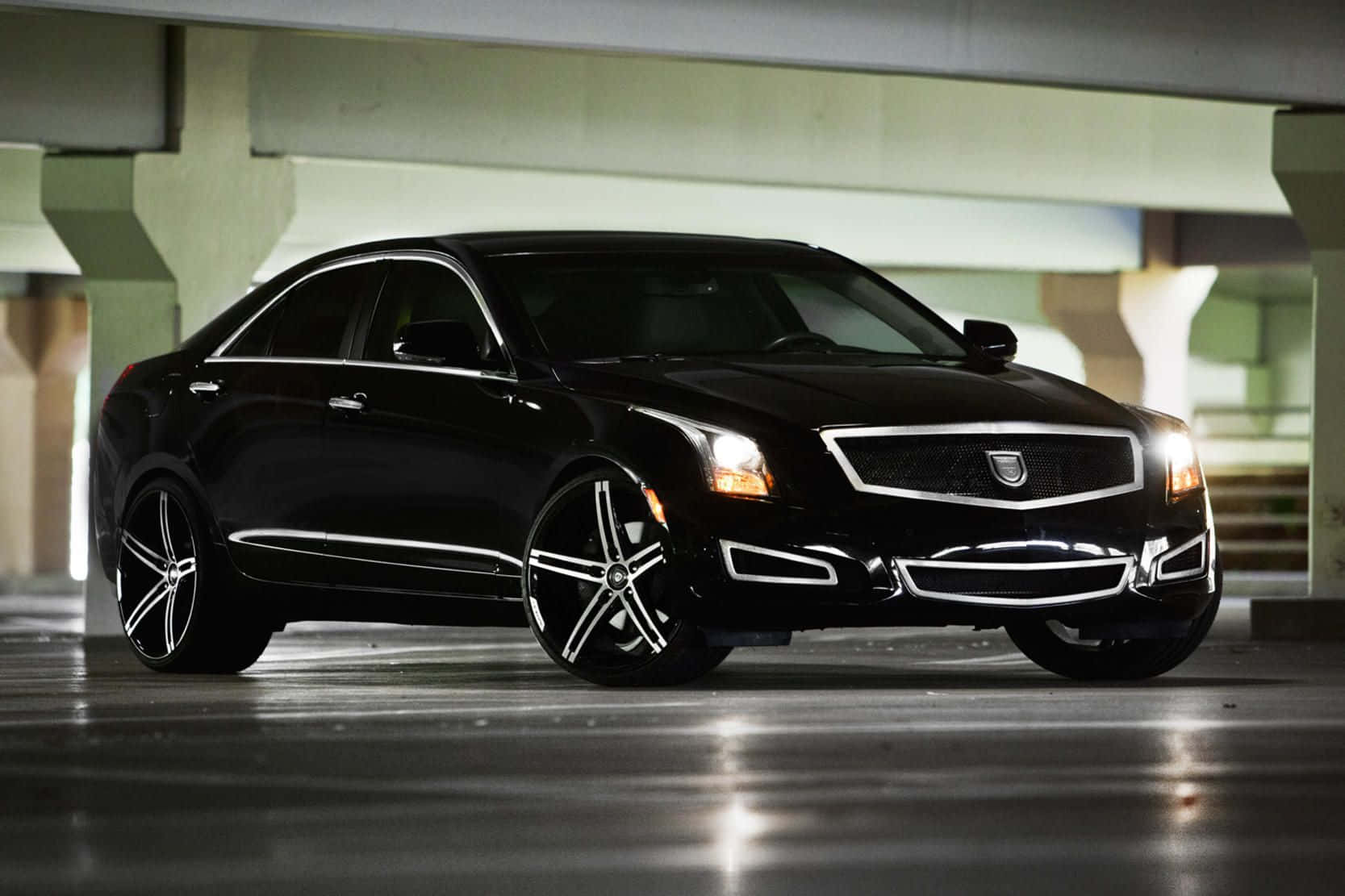 Cadillac Xts 桌布 壁紙 — 一輛配備訂製輪圈的時尚黑色Cadillac ATS在混凝土停車場的人造燈光下閃閃發光。