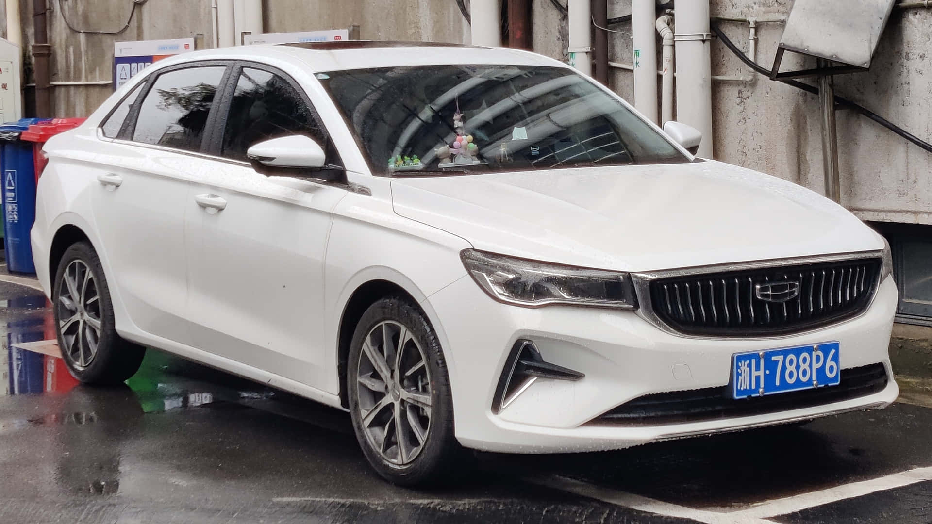  壁紙 — 一輛時尚白色轎車停泊在濕漉漉的市區街道上，光澤表面映出倒影，並帶有藍色車牌。