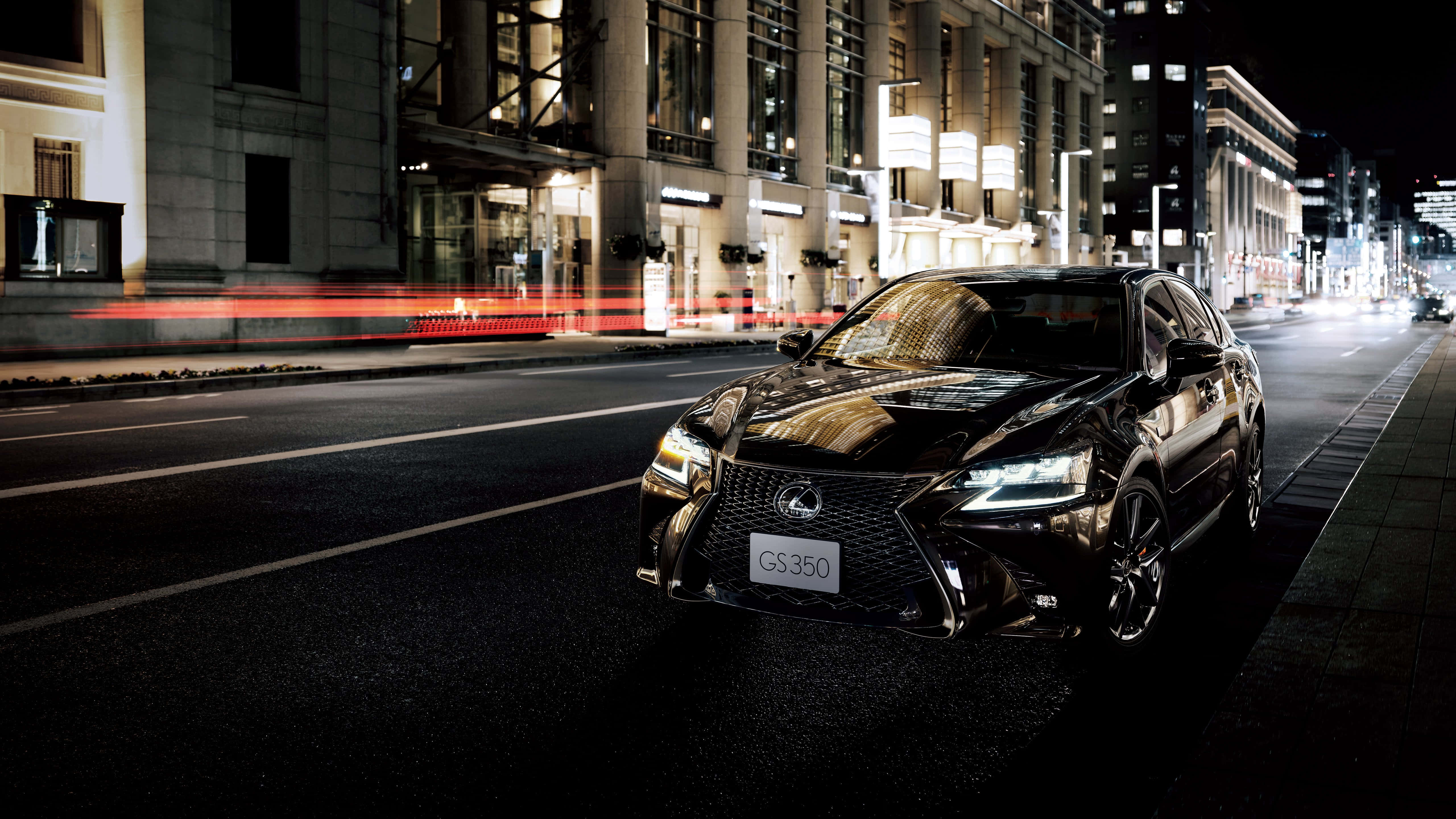 Lexus Gs 桌布 壁紙 — 一輛時尚的黑色Lexus GS350在夜晚穿梭於充滿霓虹燈光的繁華街道，留下紅色交通燈的光跡。