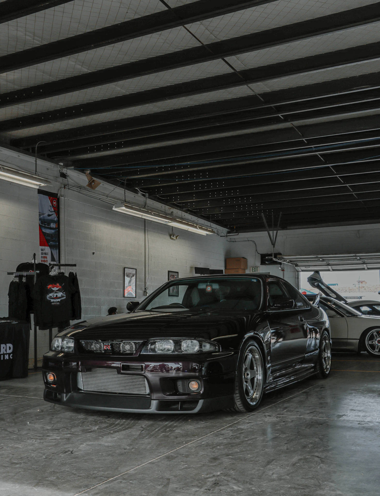 黑色日產Skyline GT-R在裸露橫樑的混凝土車庫中。 — 日產 Skyline GTR R34 壁紙
