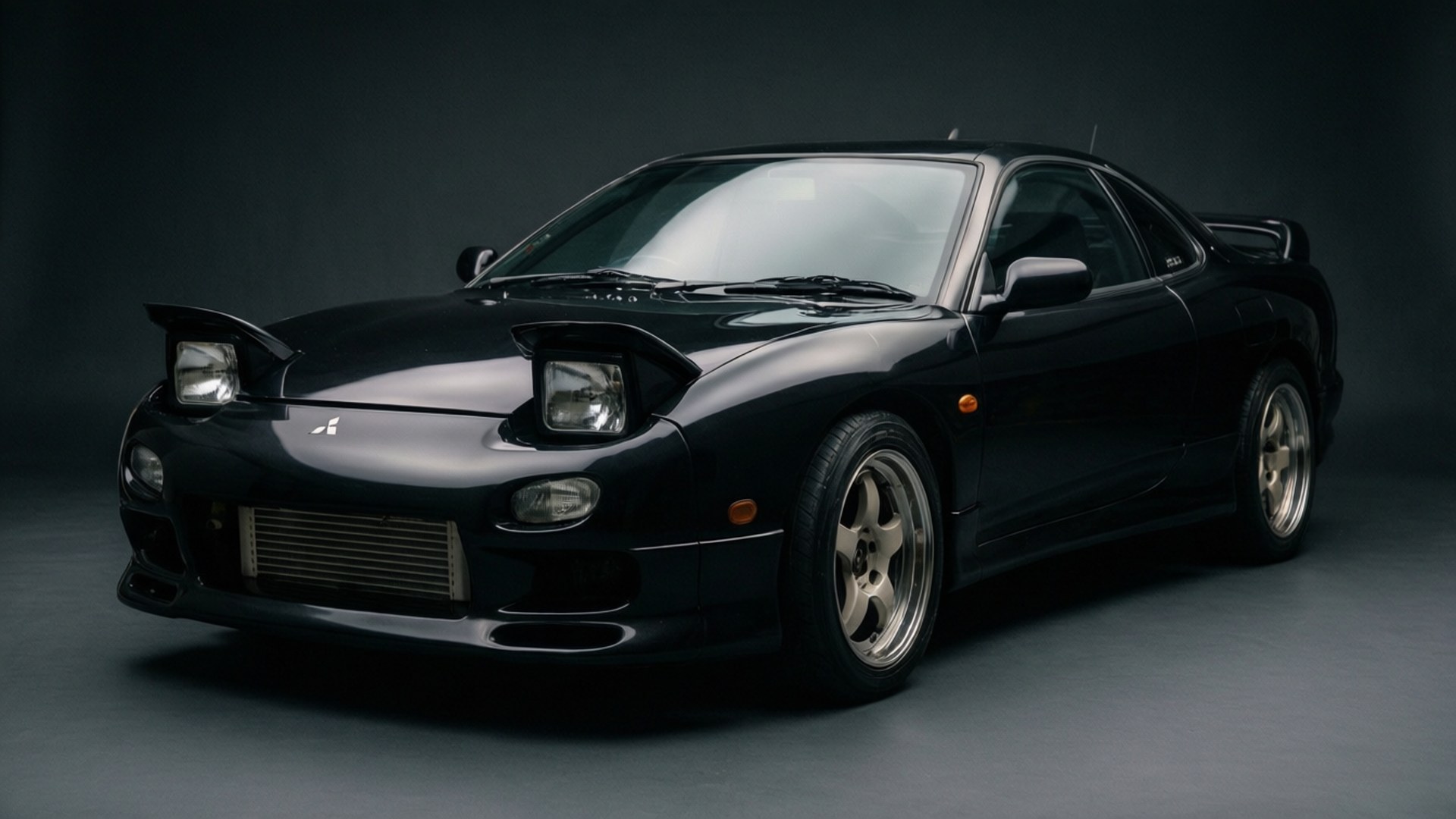 Stealth 3000GT Pop-Ups 壁紙 — 一輛時尚的黑色三菱3000GT跑車，配備銀色輪圈和前置中冷器，在黑暗的攝影棚中拍攝。