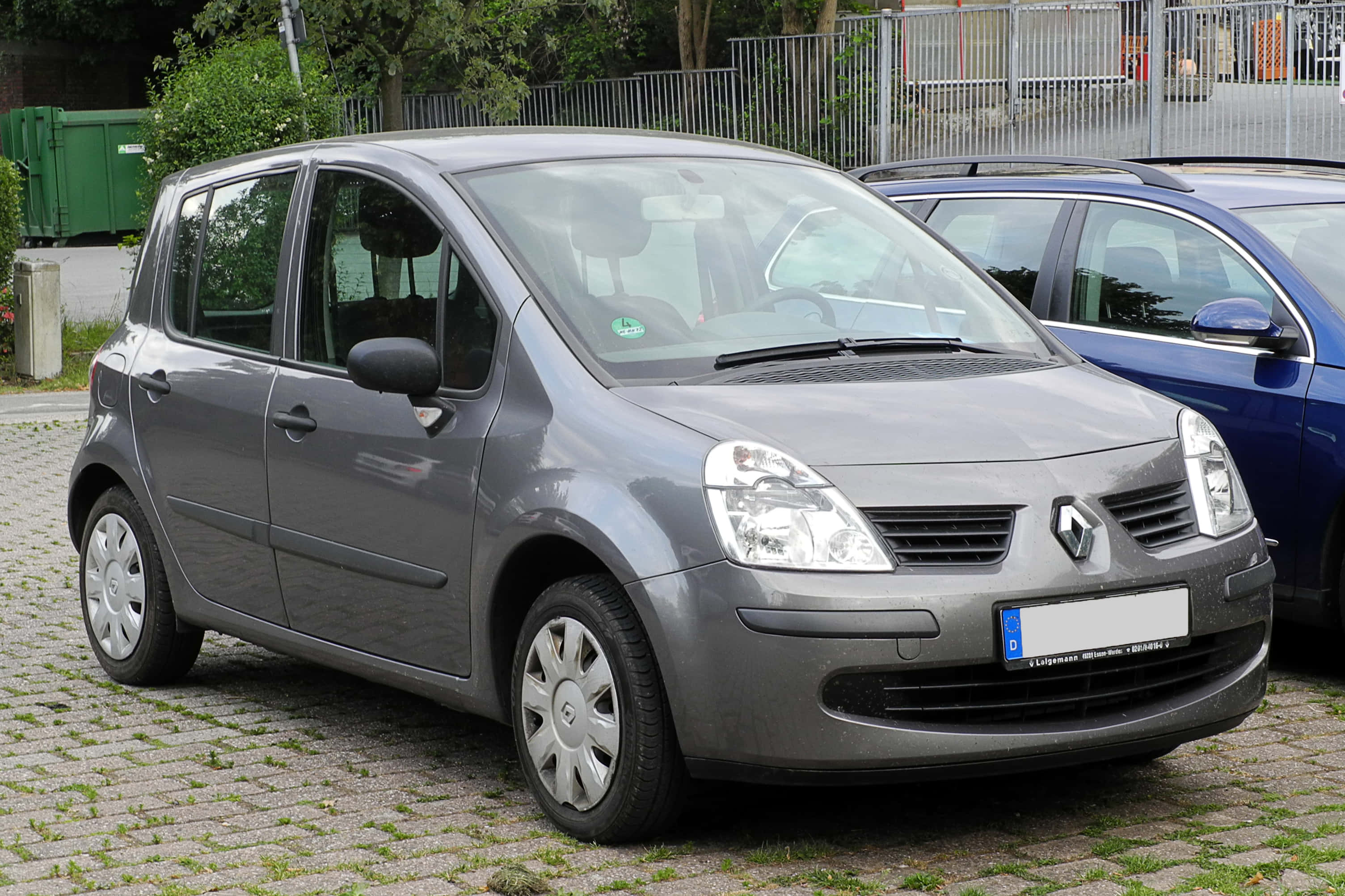 Renault Modus 桌布 壁紙 — 一輛時尚的灰色雷諾Scenic停放在鵝卵石地上，背景有綠化和圍欄。