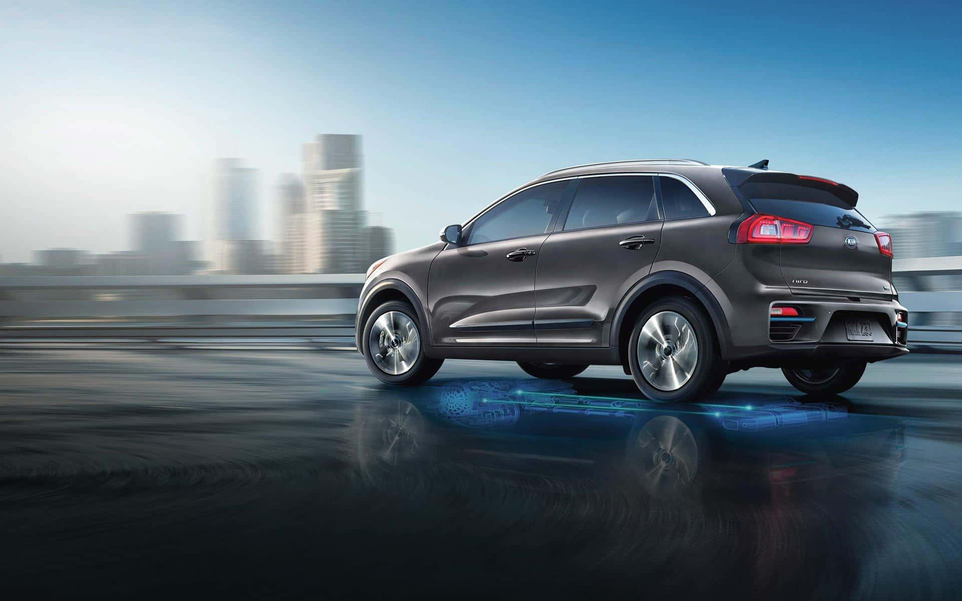 Kia Niro 桌布 壁紙 — 一輛時尚的灰色SUV在濕潤的城市高速公路上飛馳，模糊的城市摩天大樓在晴朗的藍天下。