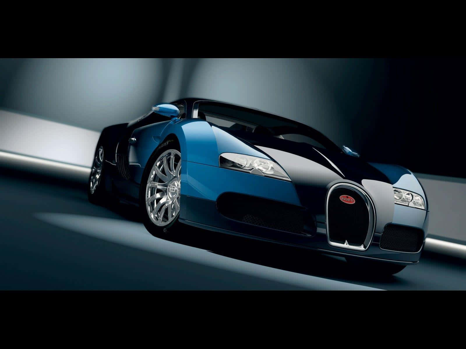 Bugatti Veyron 桌布 壁紙 — 一輛時尚的藍黑布加迪跑車在戲劇性的攝影棚燈光下滑行，帶有銀色飾邊和拋光輪圈。