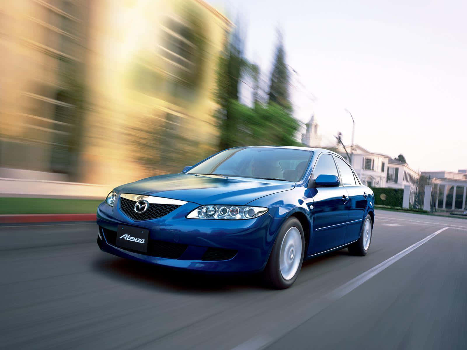 Mazda 6 桌布 壁紙 — 一輛時尚的藍色馬自達 Atenza 在陽光明媚的街道上奔馳，背景呈現動態模糊效果。