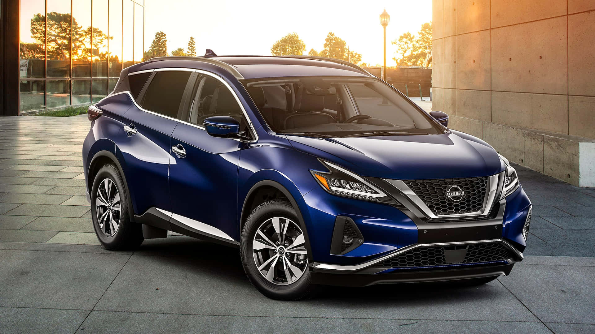 Nissan Murano 桌布 壁紙 — 一輛時尚的藍色日產Rogue SUV停泊在現代瓷磚廣場上，正值黃金時刻，溫暖的陽光投下長長的影子。
