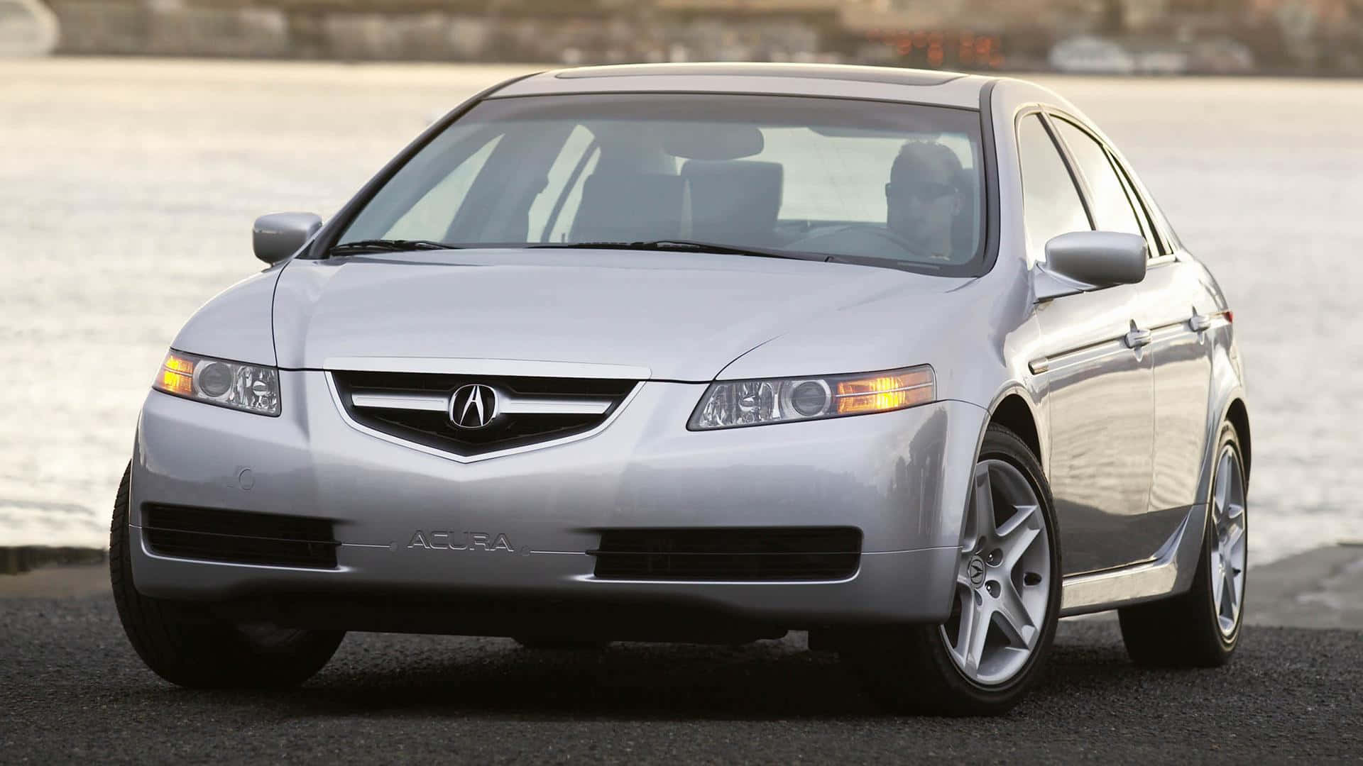 Acura Tl 桌布 壁紙 — 一輛時尚的銀色Acura轎車停泊在平靜的水邊，伴隨著柔和的金色燈光。