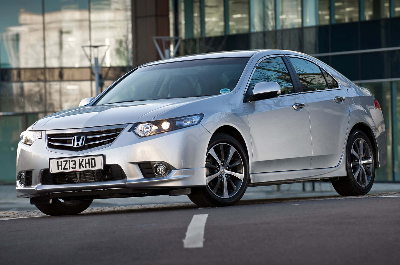 Honda Accord 桌布 壁紙 — 一輛時尚的銀色本田雅閣轎車停泊在城市的街道上，背景是現代化的玻璃建築。