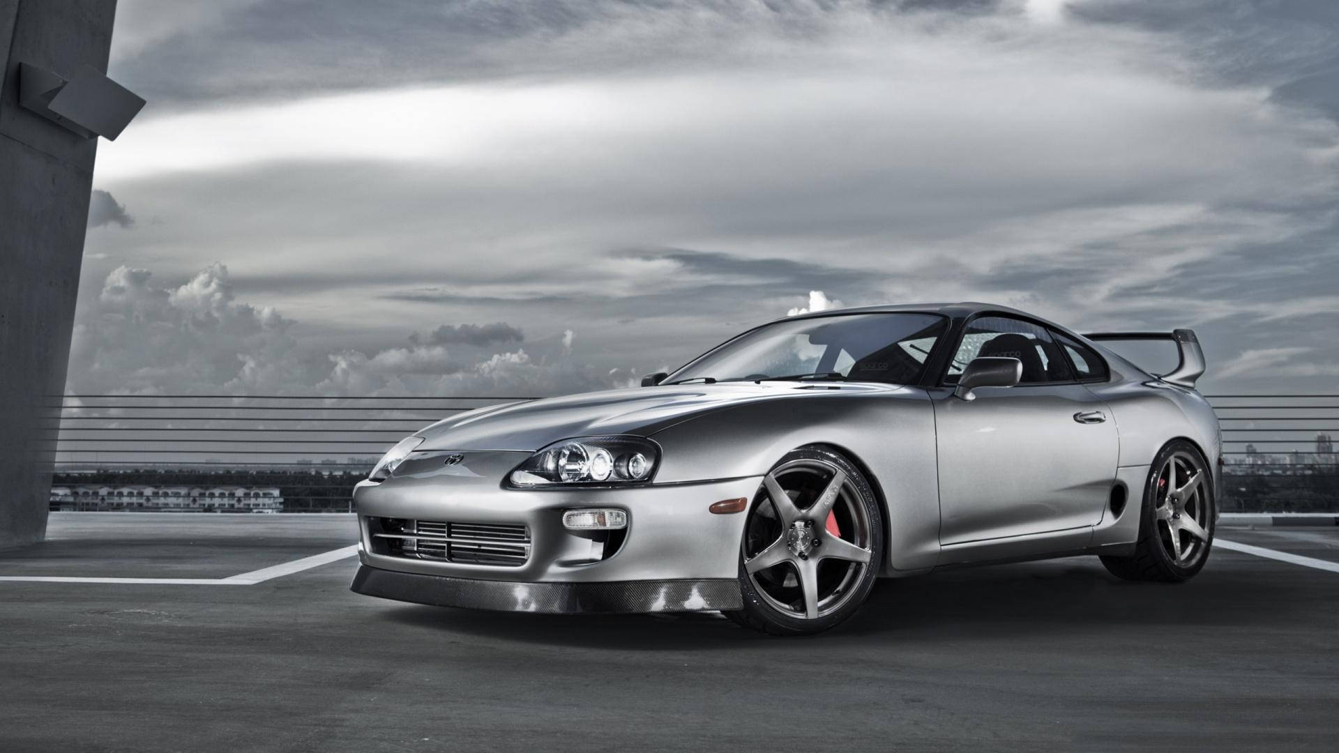 銀色跑車停泊在天橋上，陰天。 — Toyota Supra 壁紙