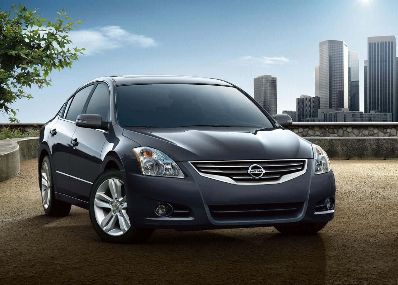 Nissan Altima 桌布 壁紙 — 一輛時尚深藍色日產轎車停放在陽光普照的觀景點，背景是現代城市天際線。