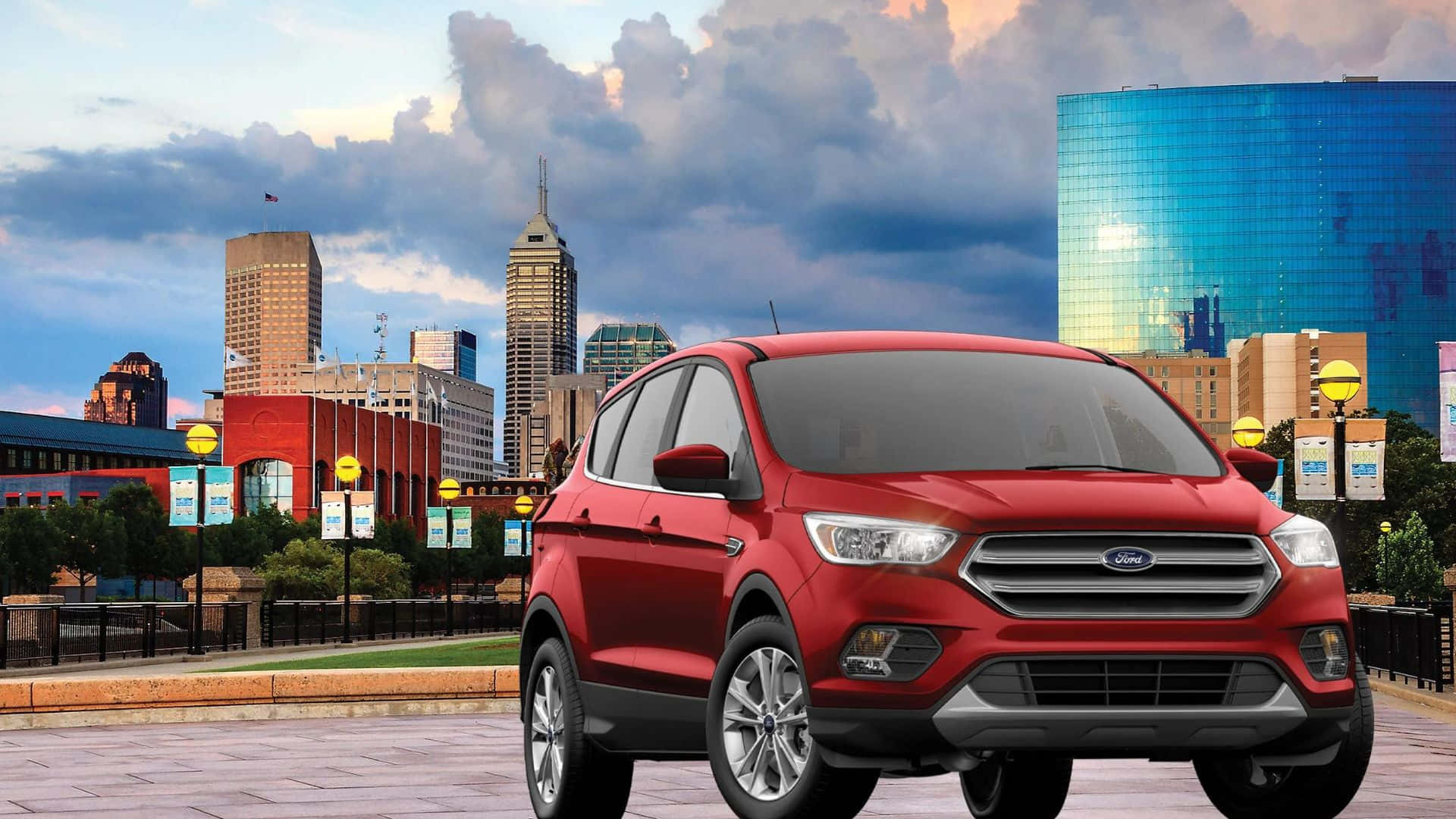 Ford Escape 桌布 壁紙 — 一輛鮮紅色的福特SUV停放在一個城市廣場上，廣場上有現代摩天大樓和色彩繽紛的玻璃建築，背景是戲劇性的黃昏天空。