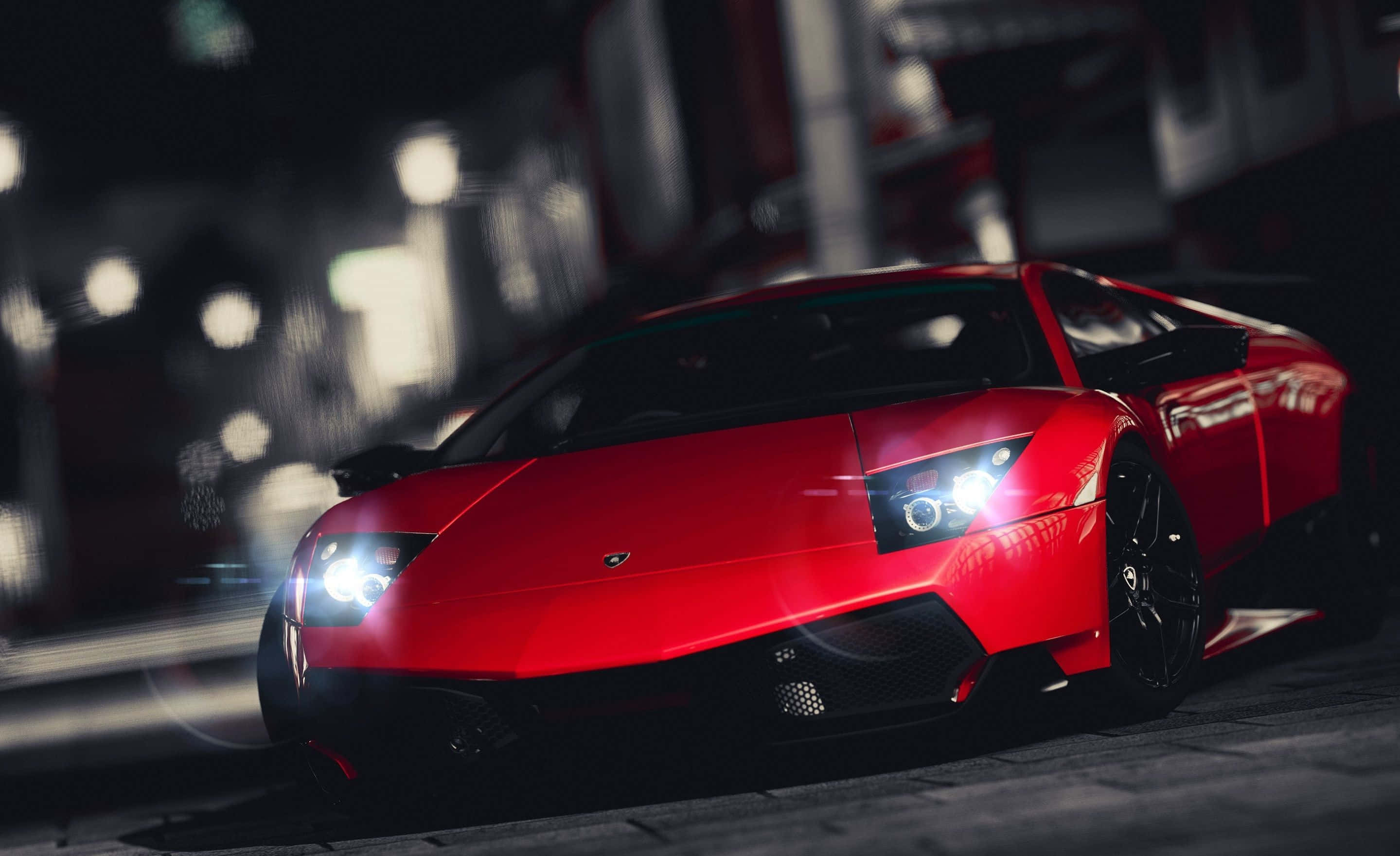 Lamborghini Murciélago 桌布 壁紙 — 一輛鮮紅色的藍寶堅尼跑車在夜晚的城市燈光下閃耀，背景是模糊的城市景觀。