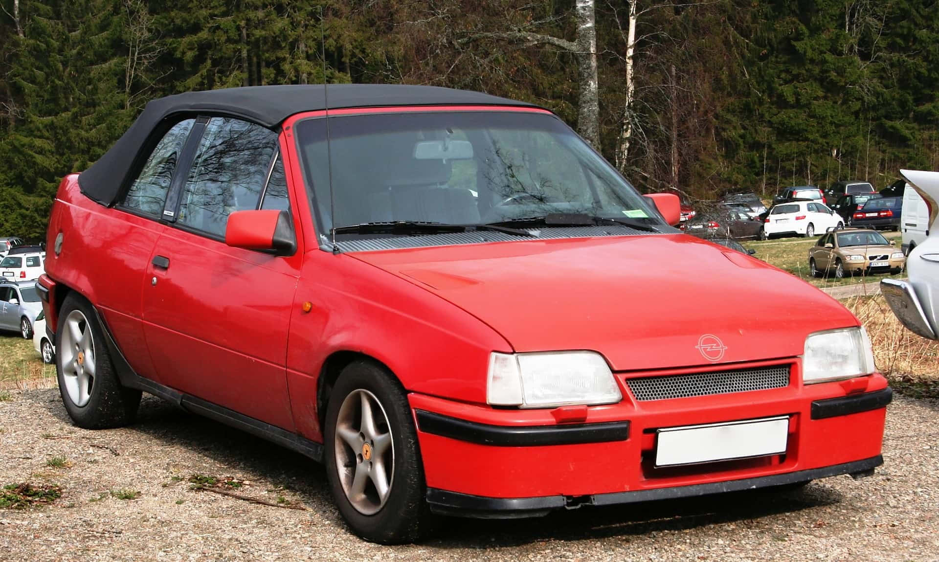 Opel Kadett 桌布 壁紙 — 一輛鮮紅色的Opel Cabriolet停放在碎石上，背景有樹木。
