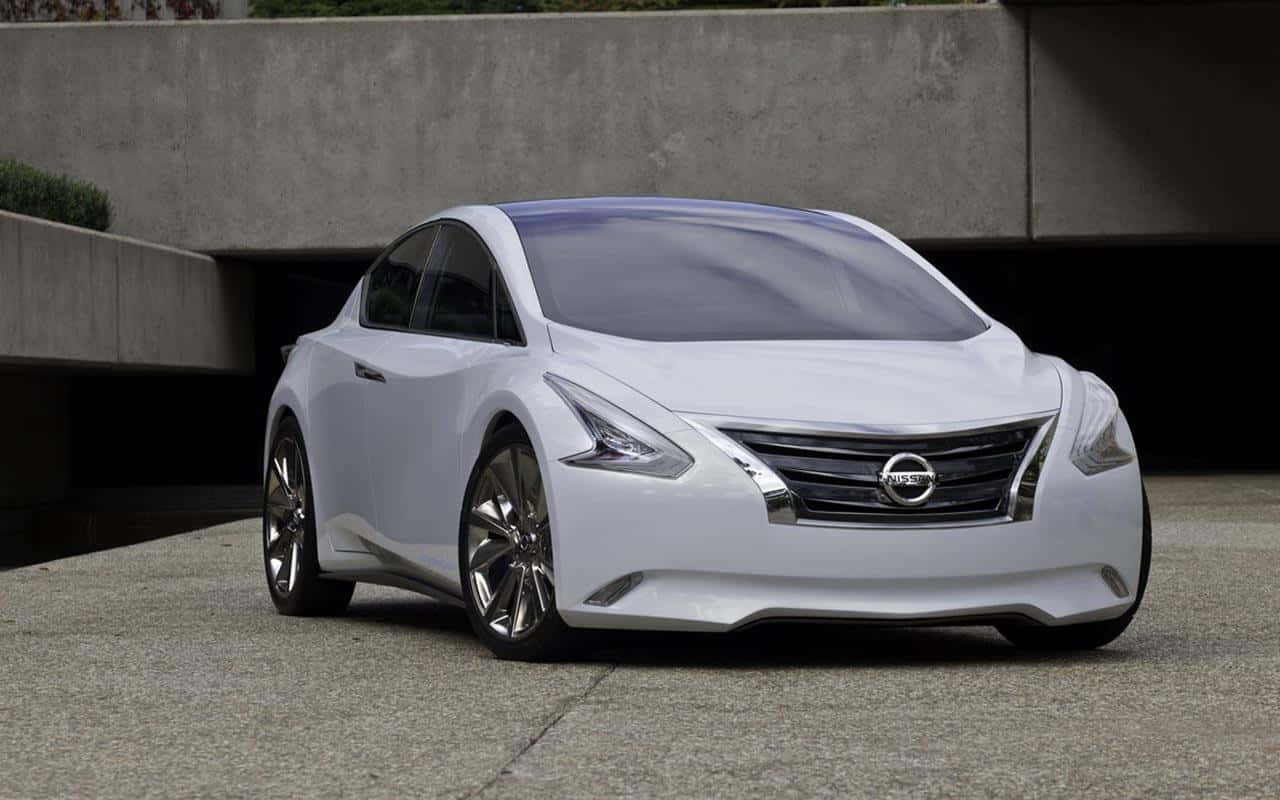 Nissan Altima 桌布 壁紙 — 一輛線條流暢的白色日產概念車，配備鋒利頭燈和鍍鉻飾件，停泊在混凝土天橋下。