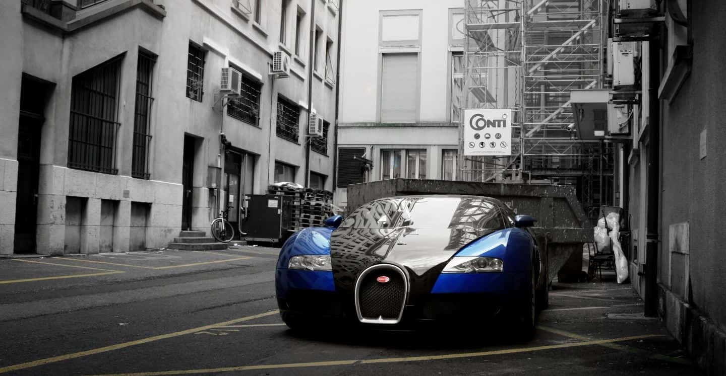 Bugatti Veyron 桌布 壁紙 — 一輛搶眼的藍色布加迪威龍停放在狹窄的城市小巷中，周圍是單色環境。