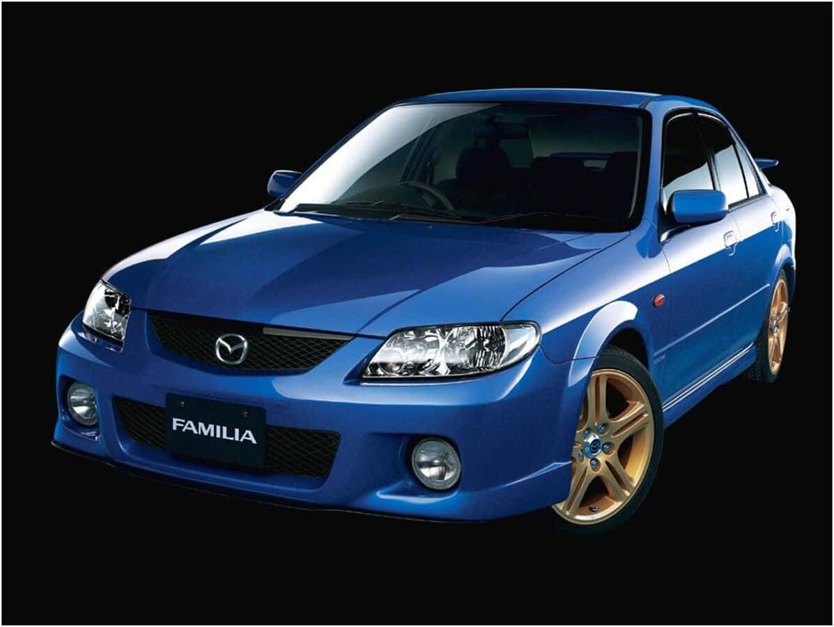 Mazda Protege 桌布 壁紙 — 一輛閃亮的藍色馬自達Familia轎車搭配金色輪圈，在純黑背景下格外突出。