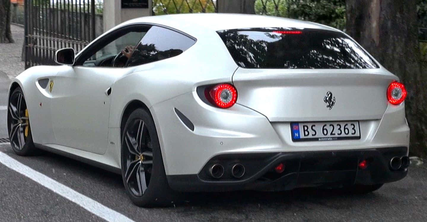 Ferrari Ff 桌布 壁紙 — 一輛時尚的白色法拉利FF停在綠樹成蔭的街道上，紅色尾燈和黃色制動卡鉗閃閃發光。