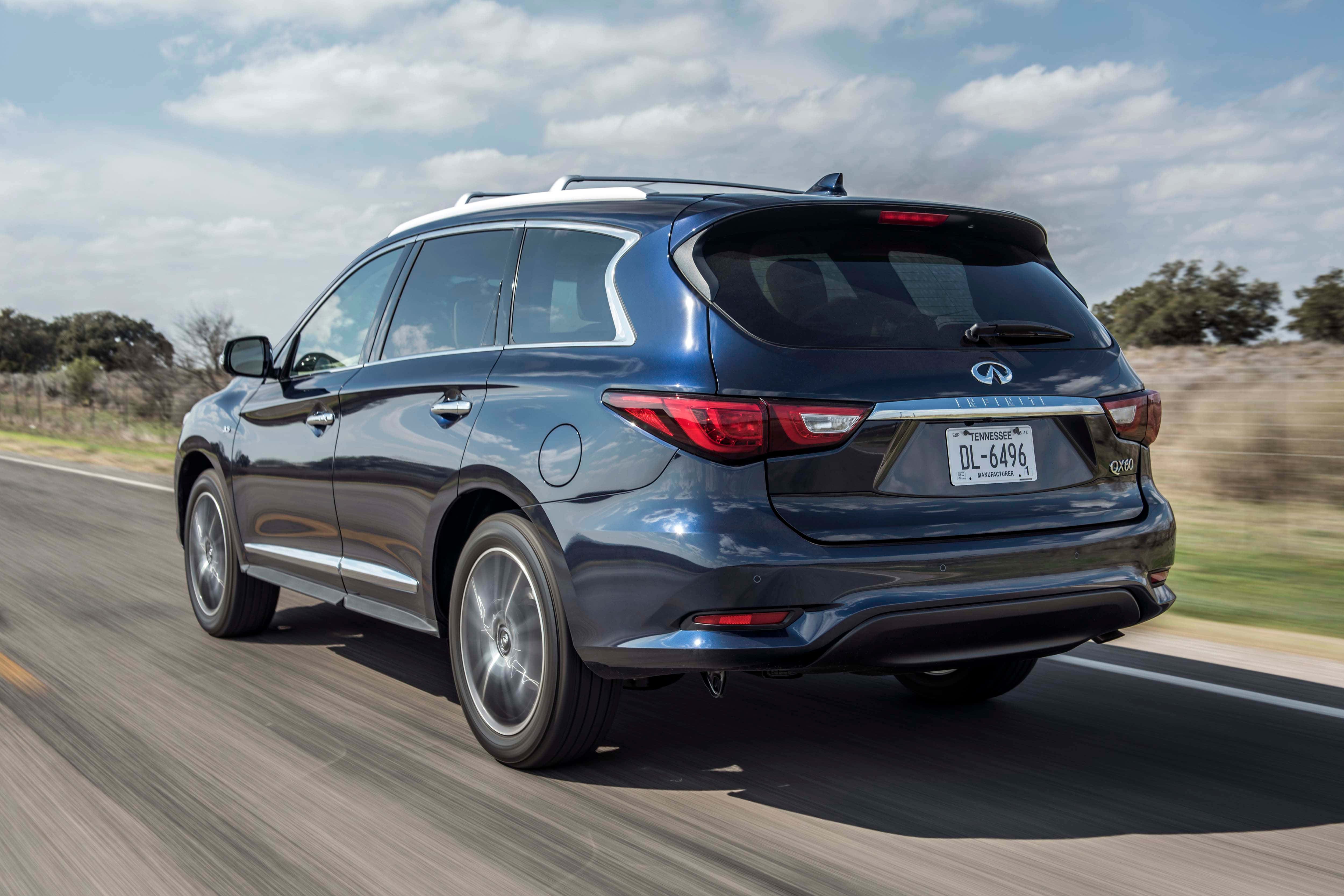 Infiniti Qx60 桌布 壁紙 — 一輛時尚的藍色 Infiniti QX60 SUV 在陽光普照的高速公路上行駛，路邊景色模糊，天空部分多雲。