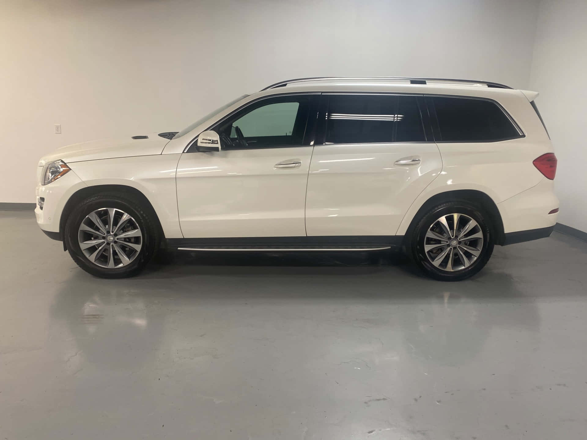 Mercedes-benz Gl-class 桌布 壁紙 — 一輛純白色的 Mercedes-Benz GLS SUV 在一個簡約的室內工作室中展示，地板具有反射效果，牆壁為中性色調。