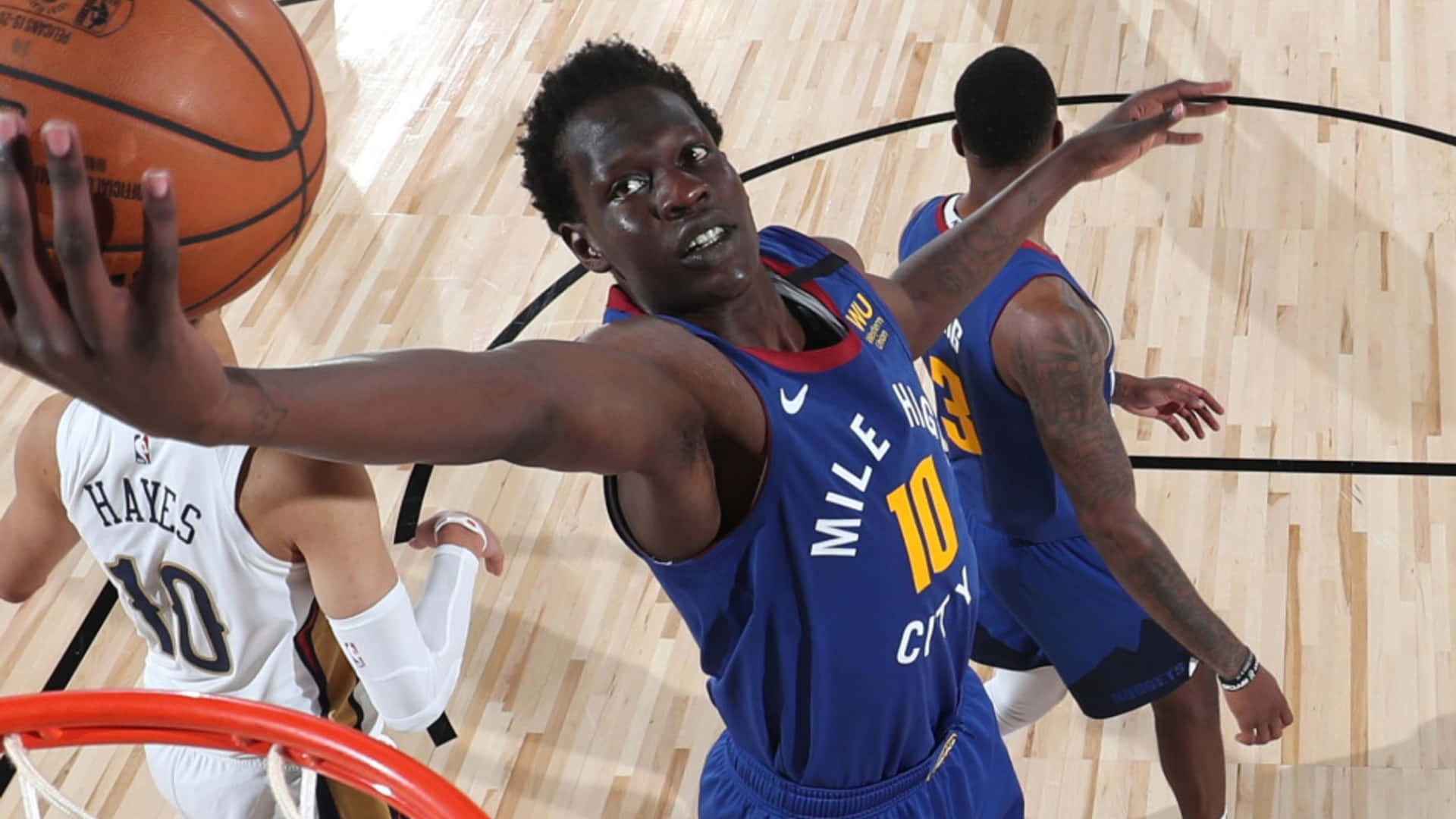 籃球運動員身穿藍色球衣在比賽中嘗試灌籃。 — NBA 壁紙
