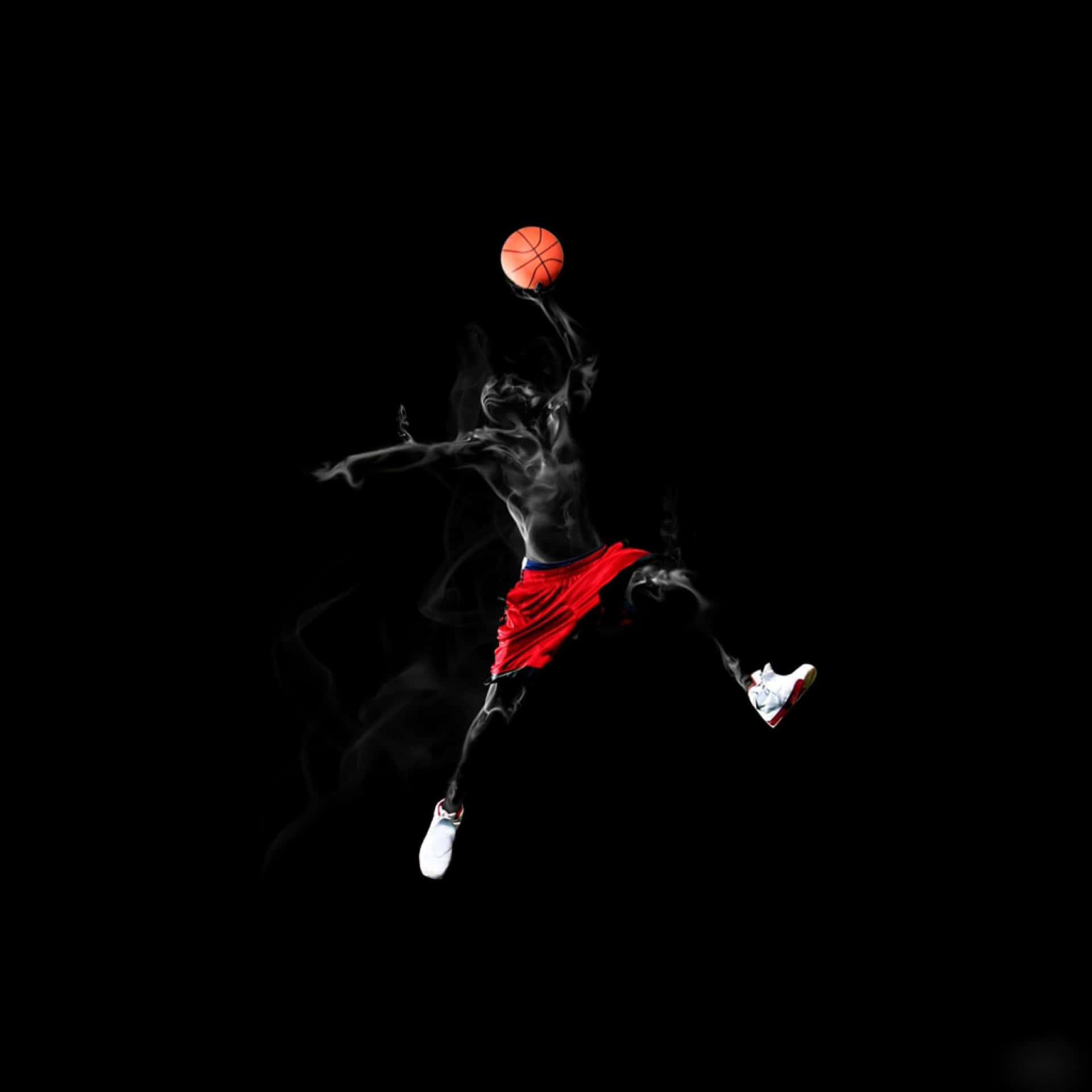 身穿紅色短褲的運動員在黑色煙霧背景上跳躍，手持籃球。 — NBA 壁紙
